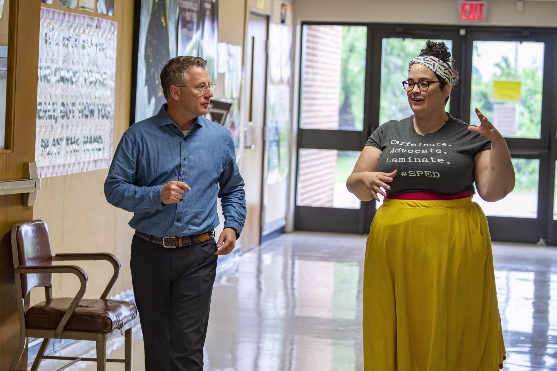 male-teacher-walking-with-high-school-student