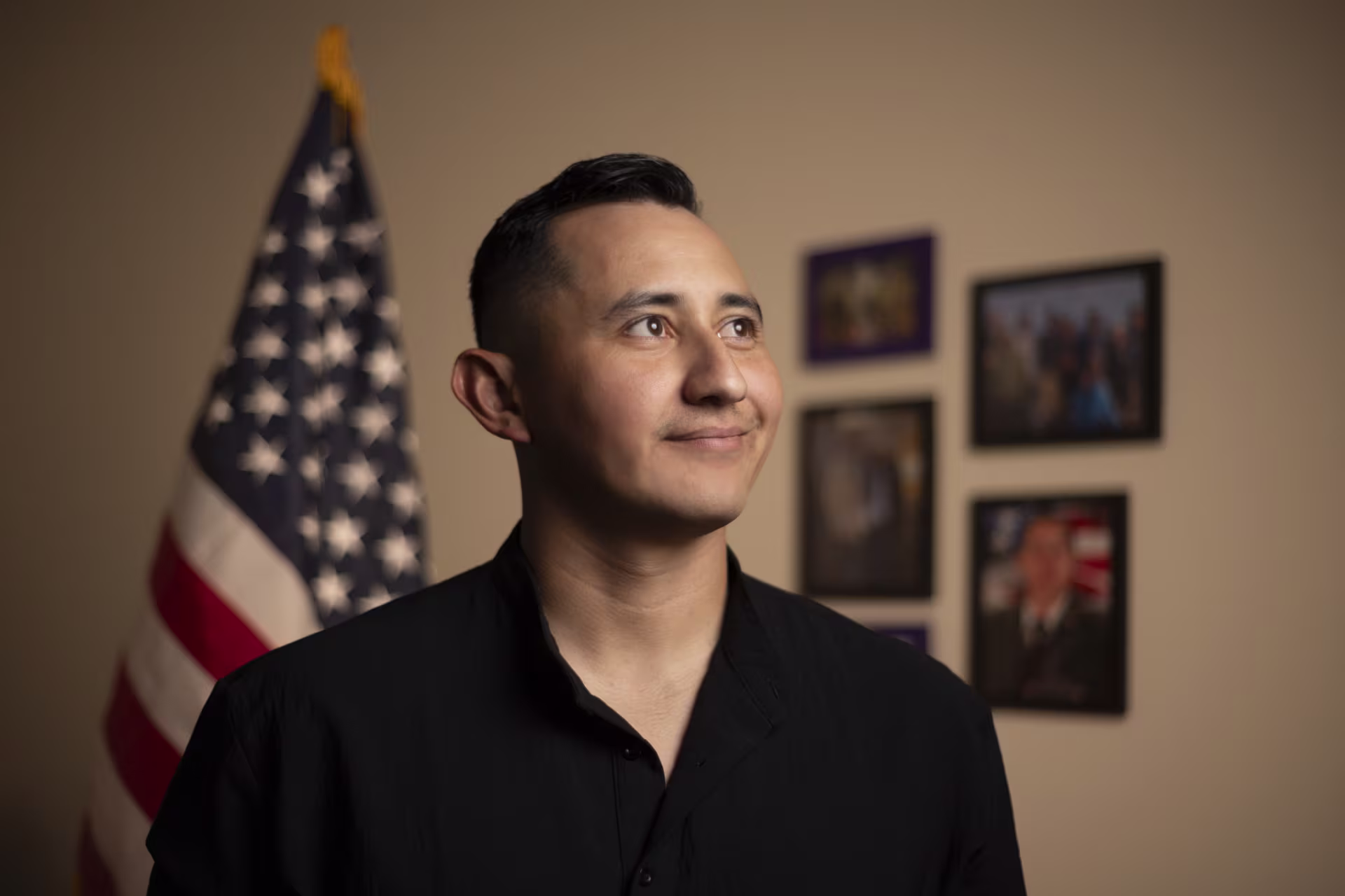 man-smiling-posing-in-front-of-flag