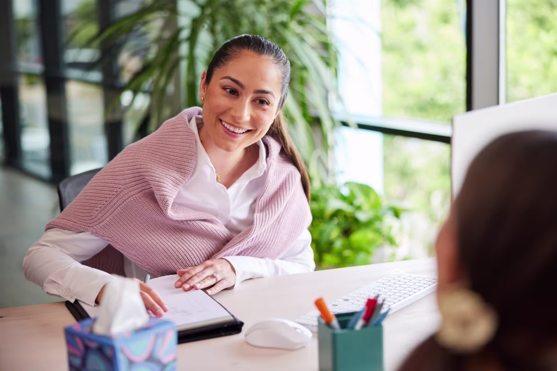social worker smiling in office and taking client notes