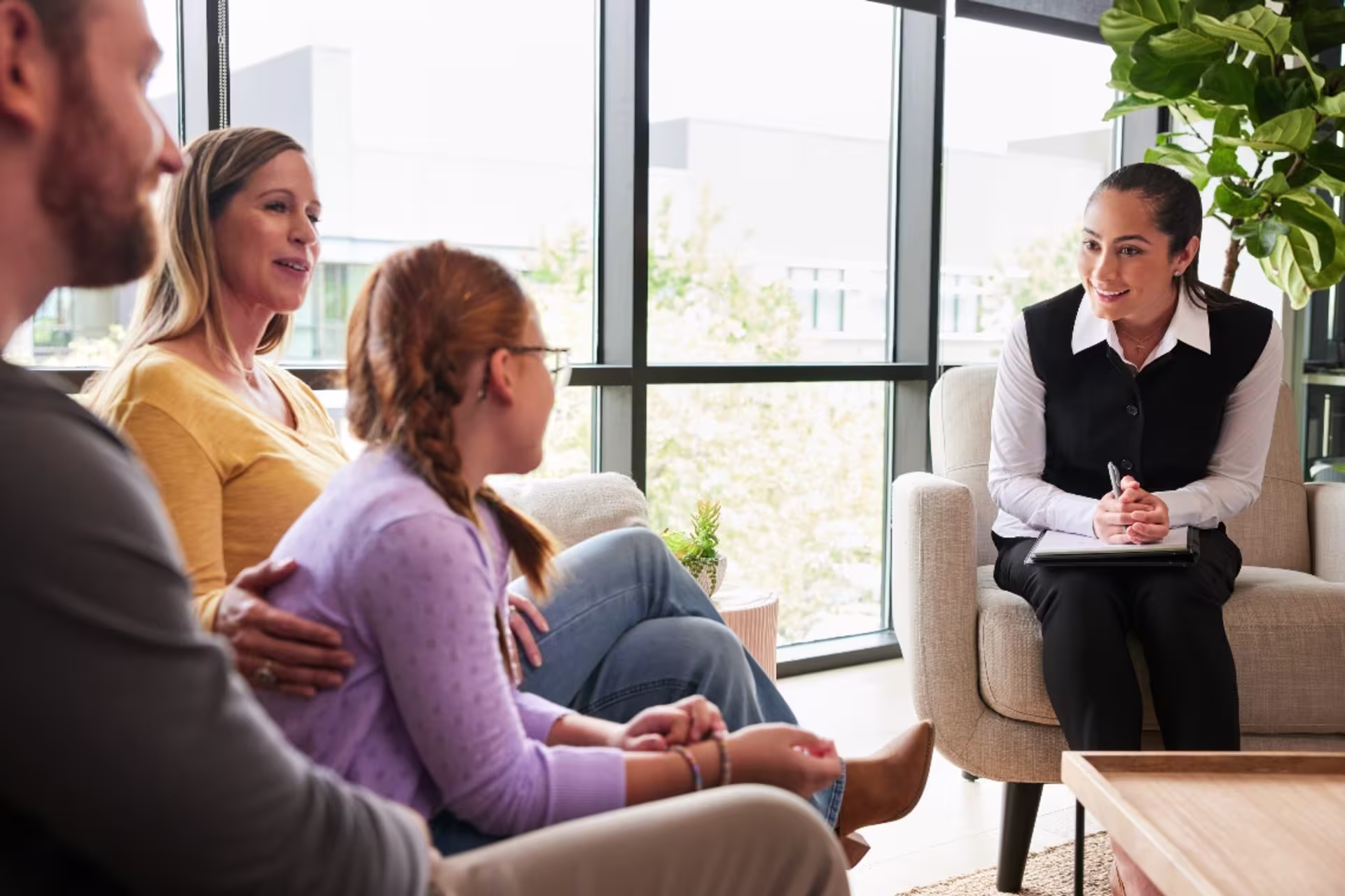 Social worker sitting in office speaking with family