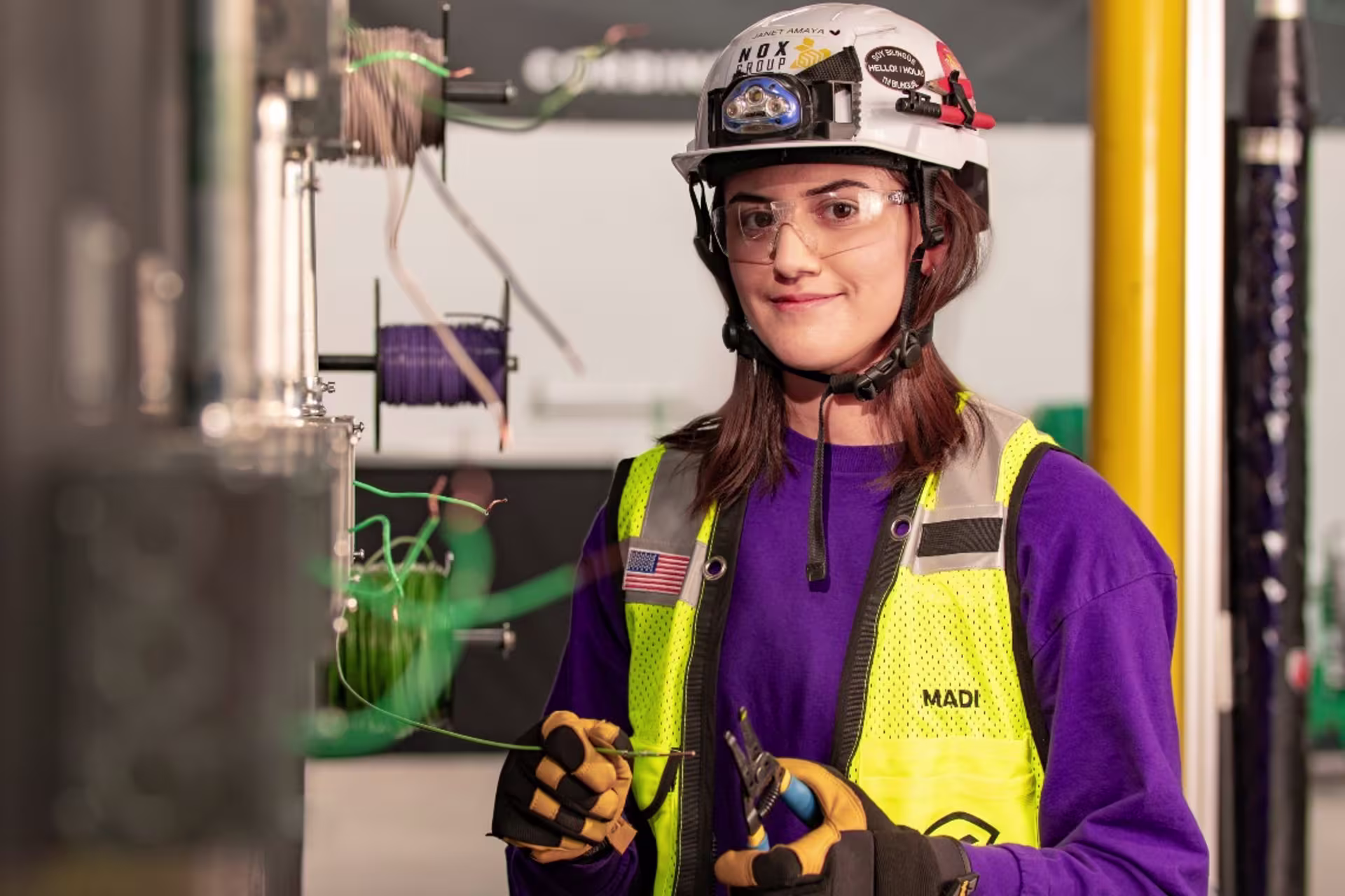 Engineering student in hard hat and vest working with wires