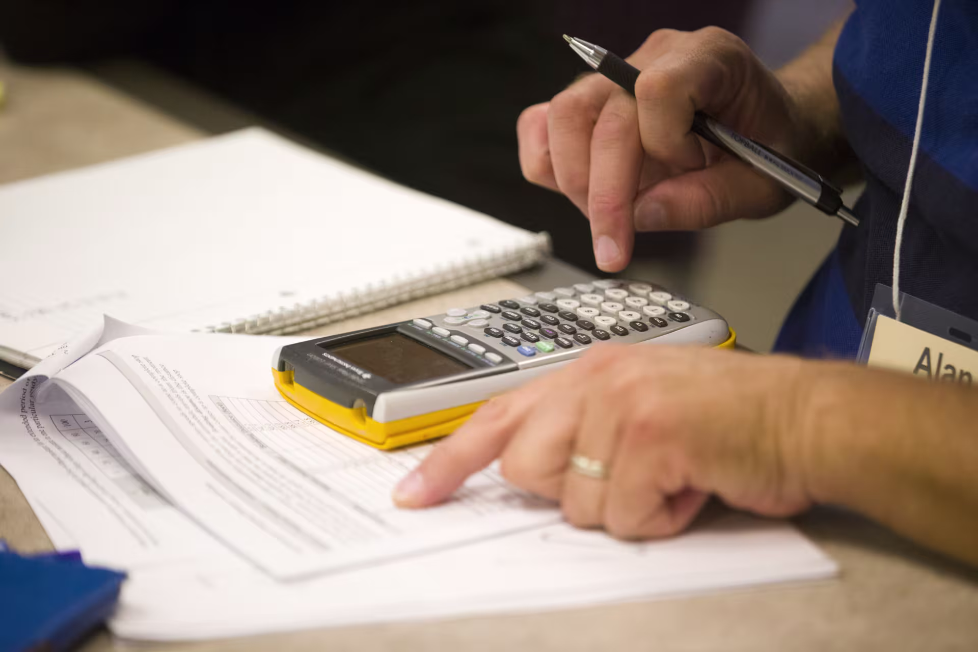 Close up image of man using calculator for MS in Accounting coursework