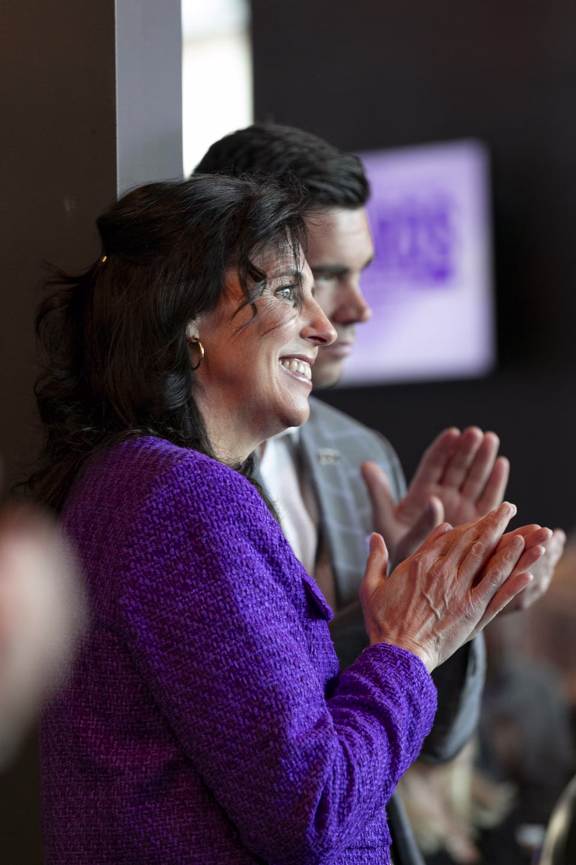 Female and male Legal Studies professionals clapping at event