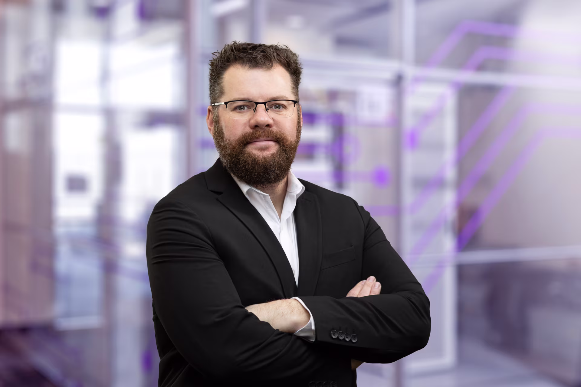 Headshot of campus technology professional wearing suit and glasses