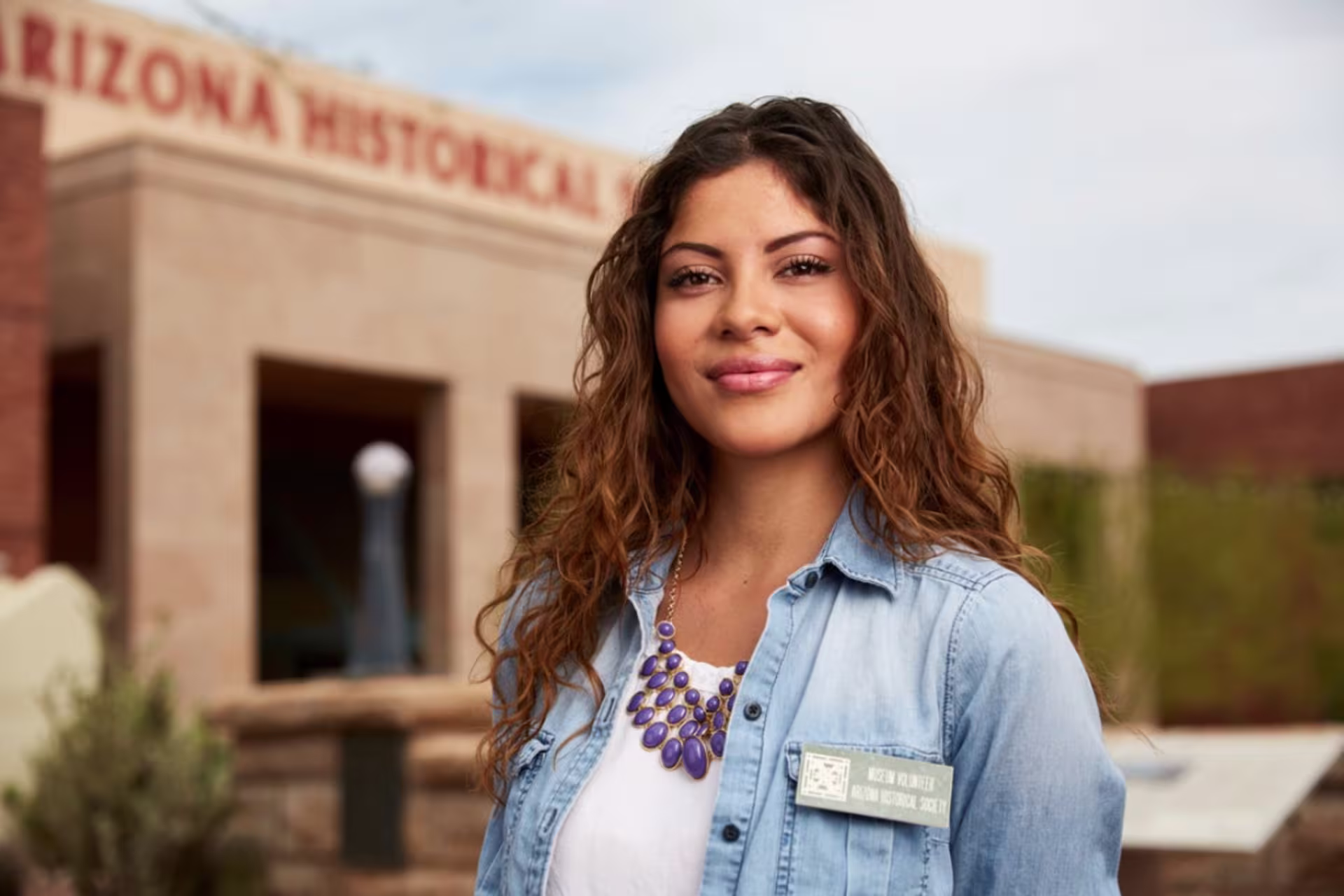 History student smiling and standing in front of a museum entrance