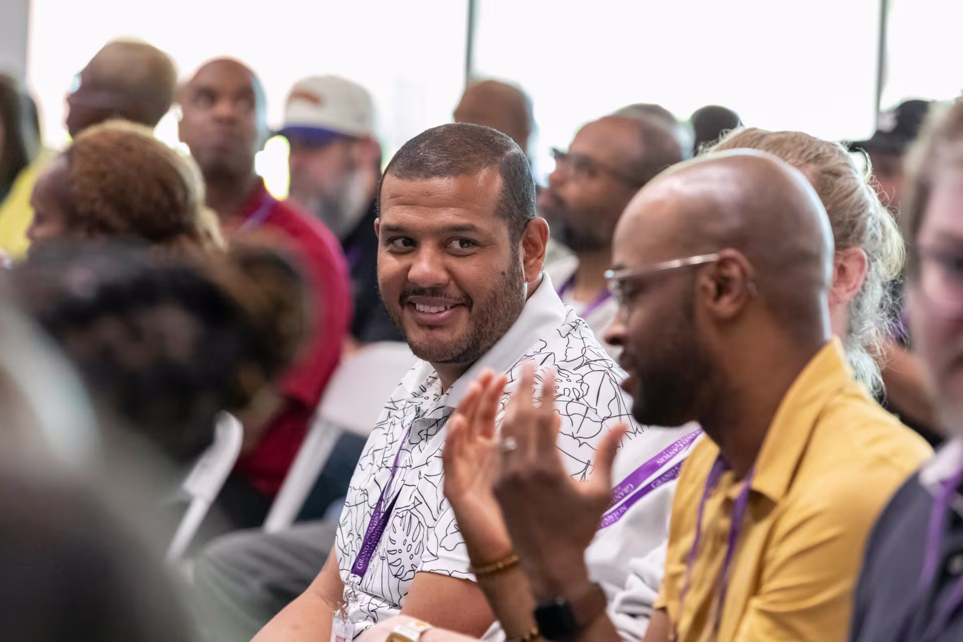 Male Christian leader speaking with man in crowd during seminar