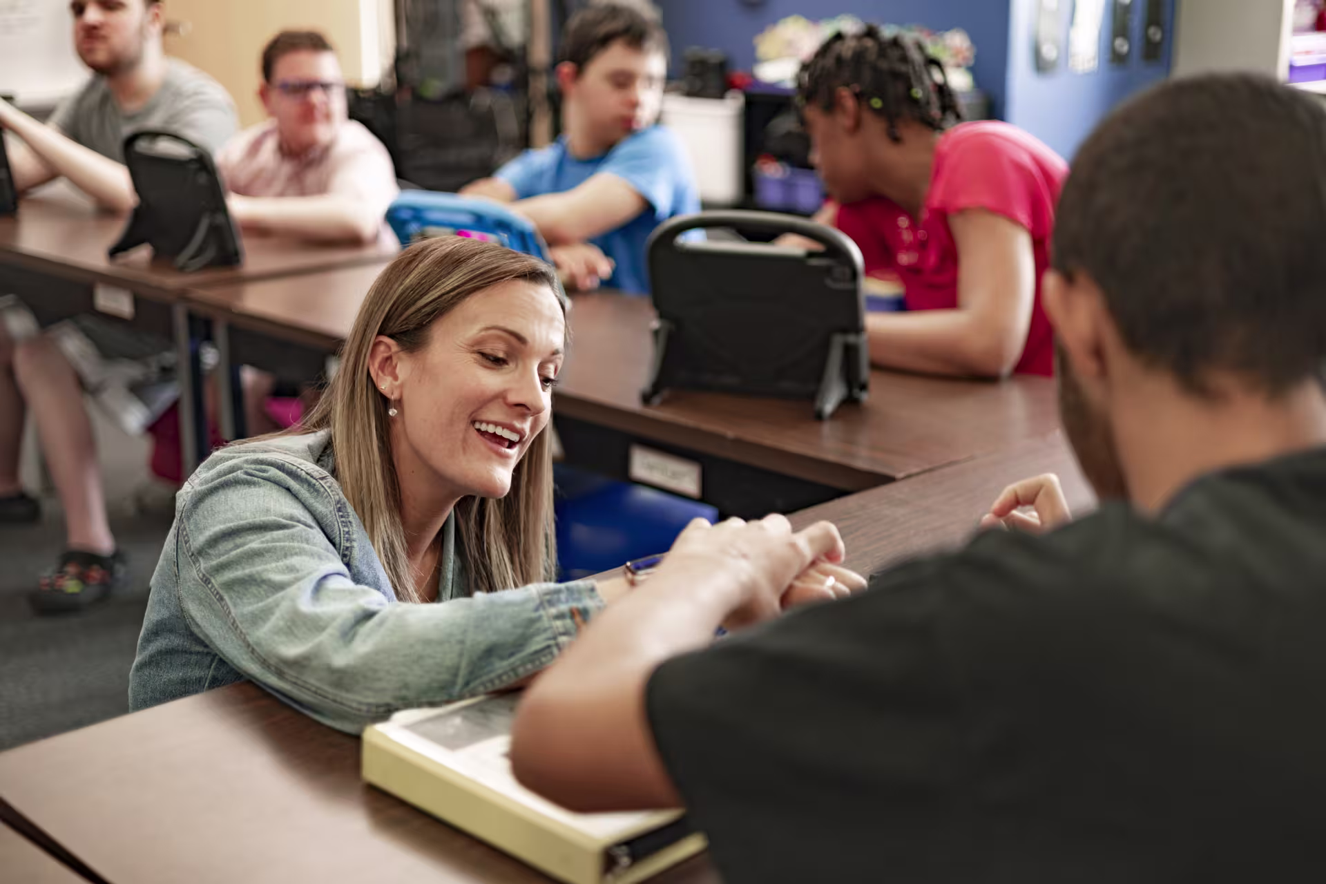 Special ed teacher helps student with assignment