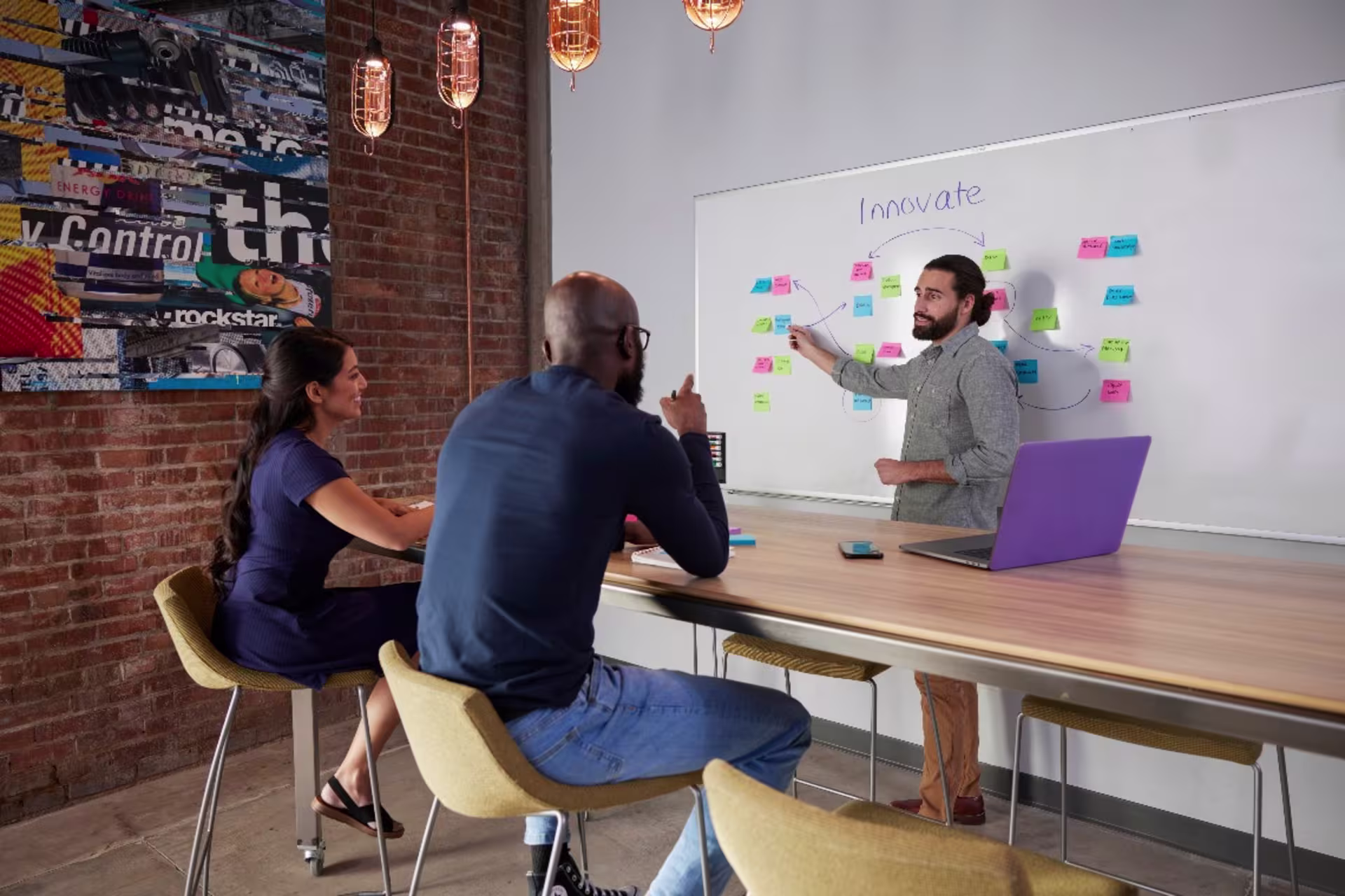 Student standing in front of whiteboard that reads "innovation" and presenting