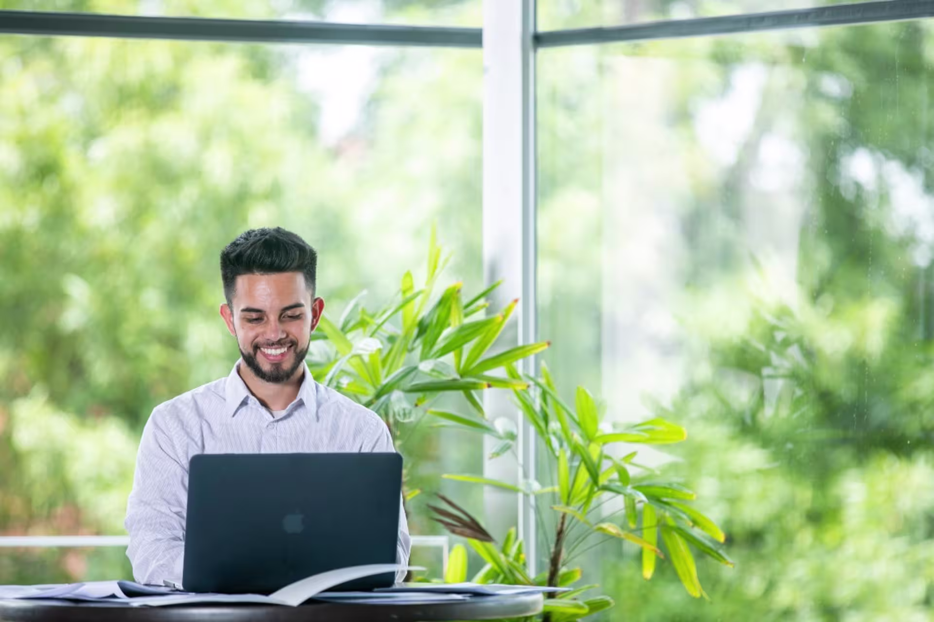 student working on laptop surrounded by plants