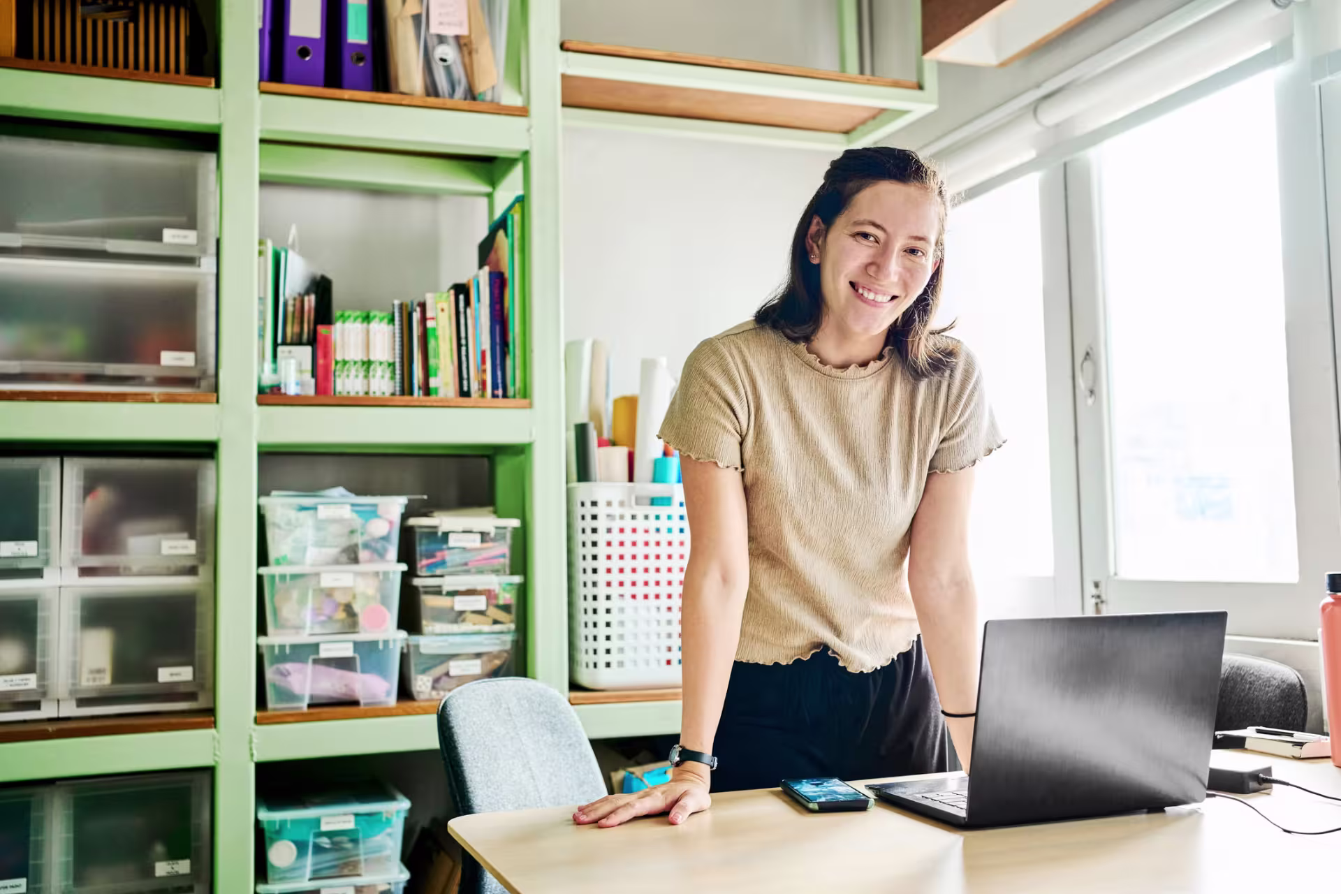 Nonprofit management worker smiles at her desk