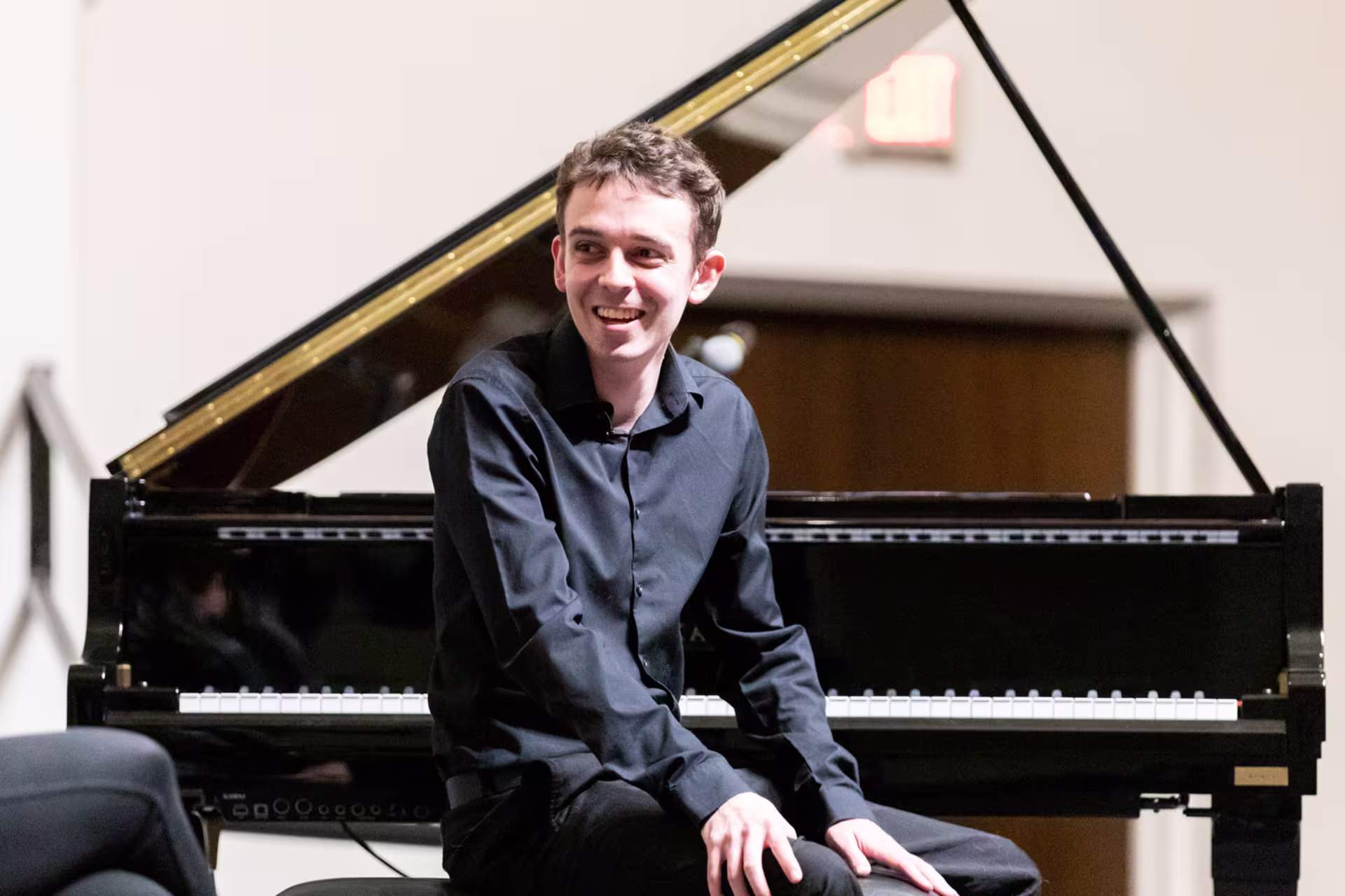 GCU student seated at a grand piano, highlighting piano performance in a recital setting.