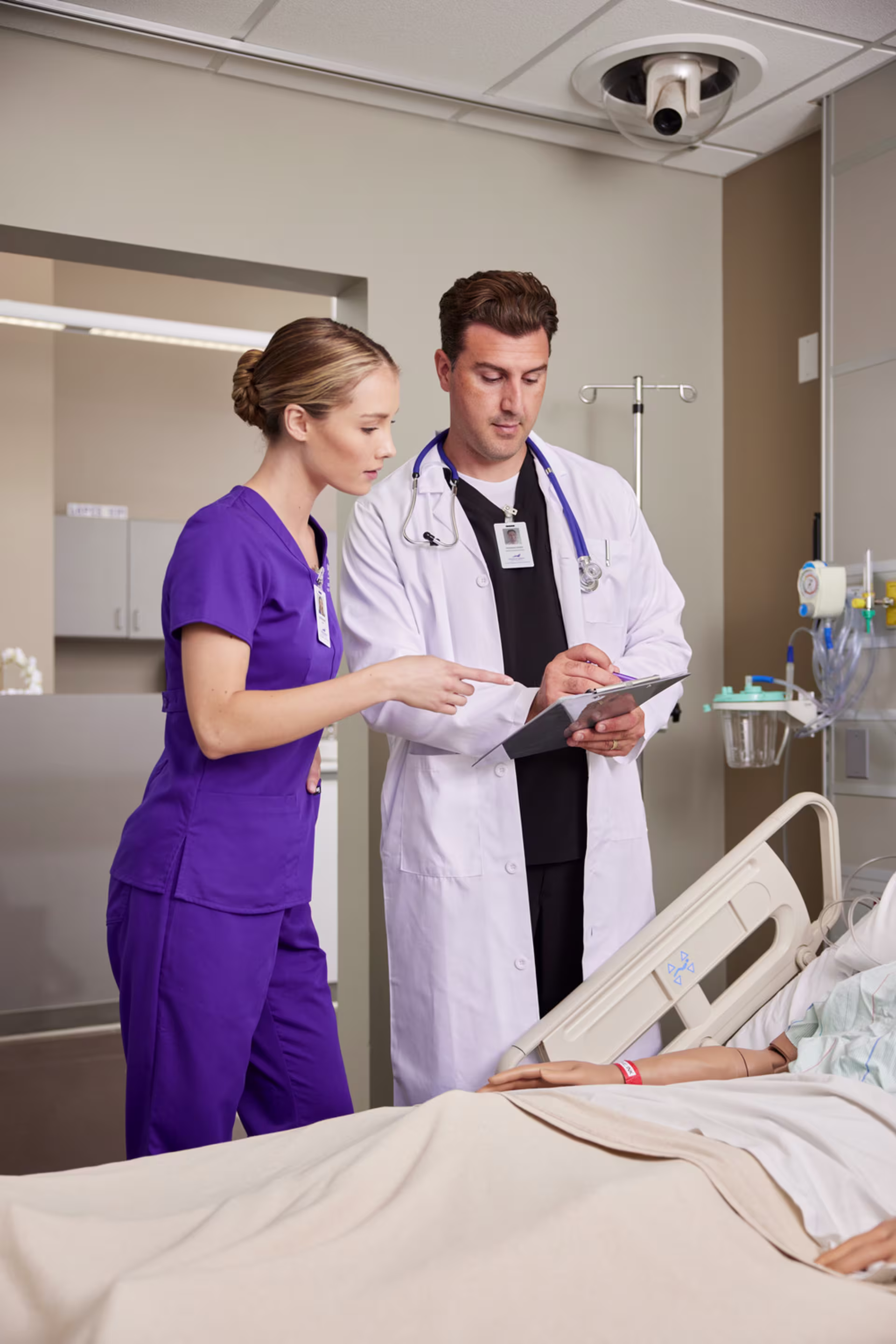 A undergraduate nursing student talking to the doctor about patient care.