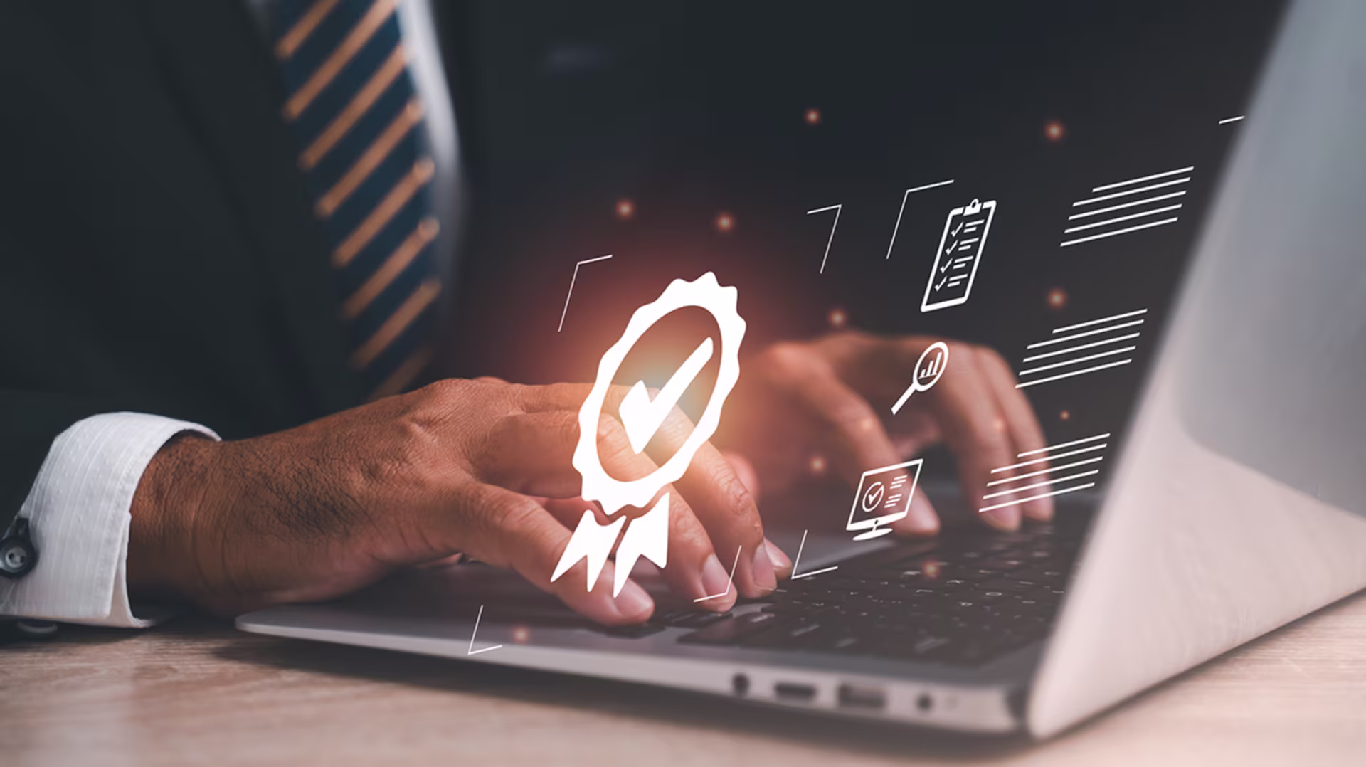 Man in suit and tie uses laptop with accreditation symbols illuminated