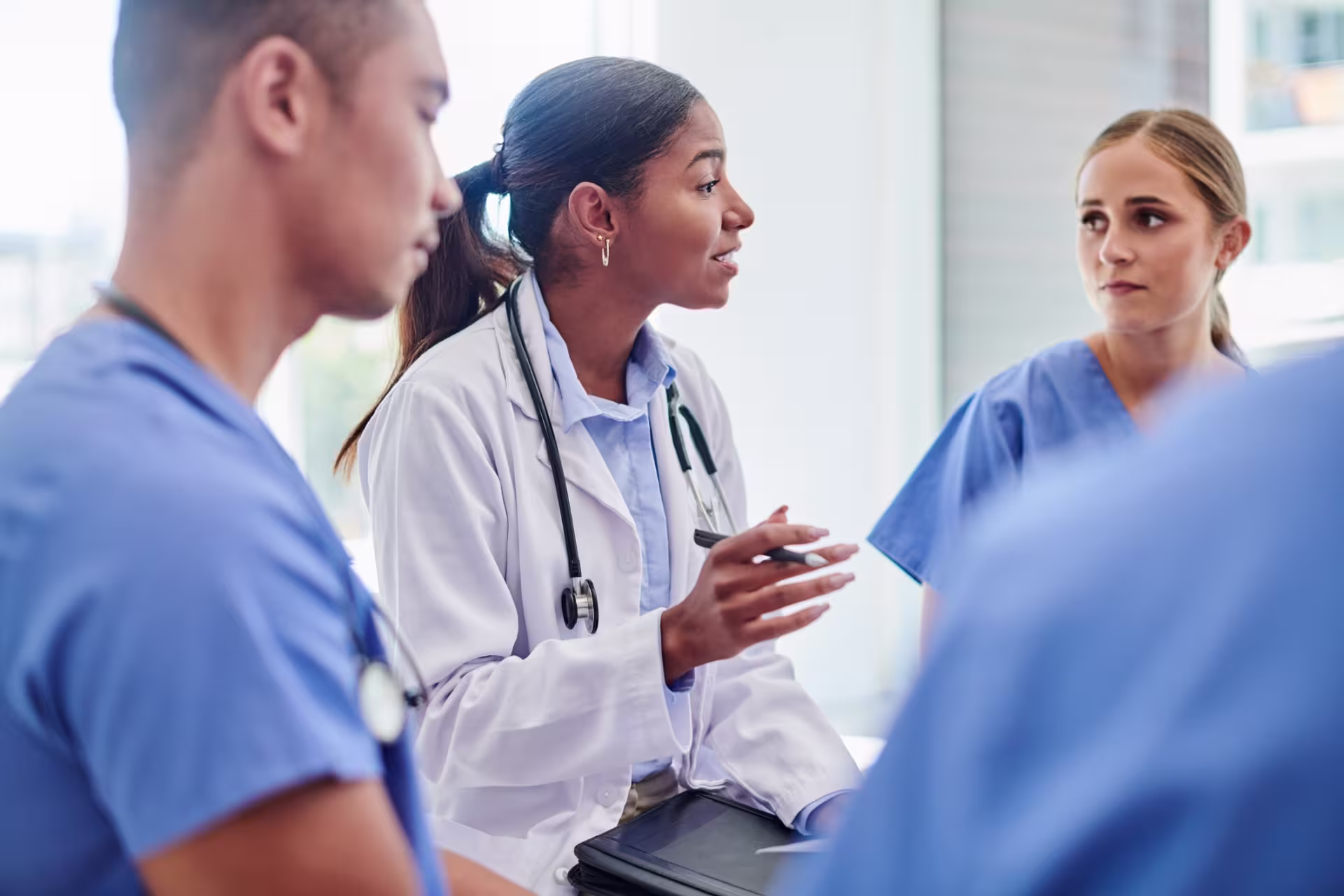 A DNP in educational leadership guiding a discussion with nursing students, providing mentorship and expertise in a clinical setting.