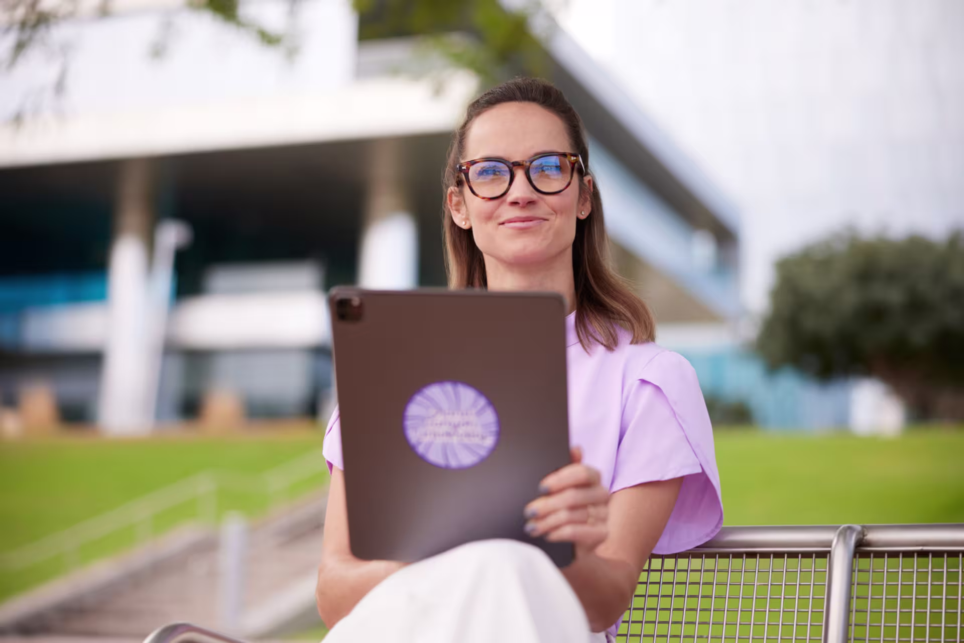 A woman using a table on a bench outside