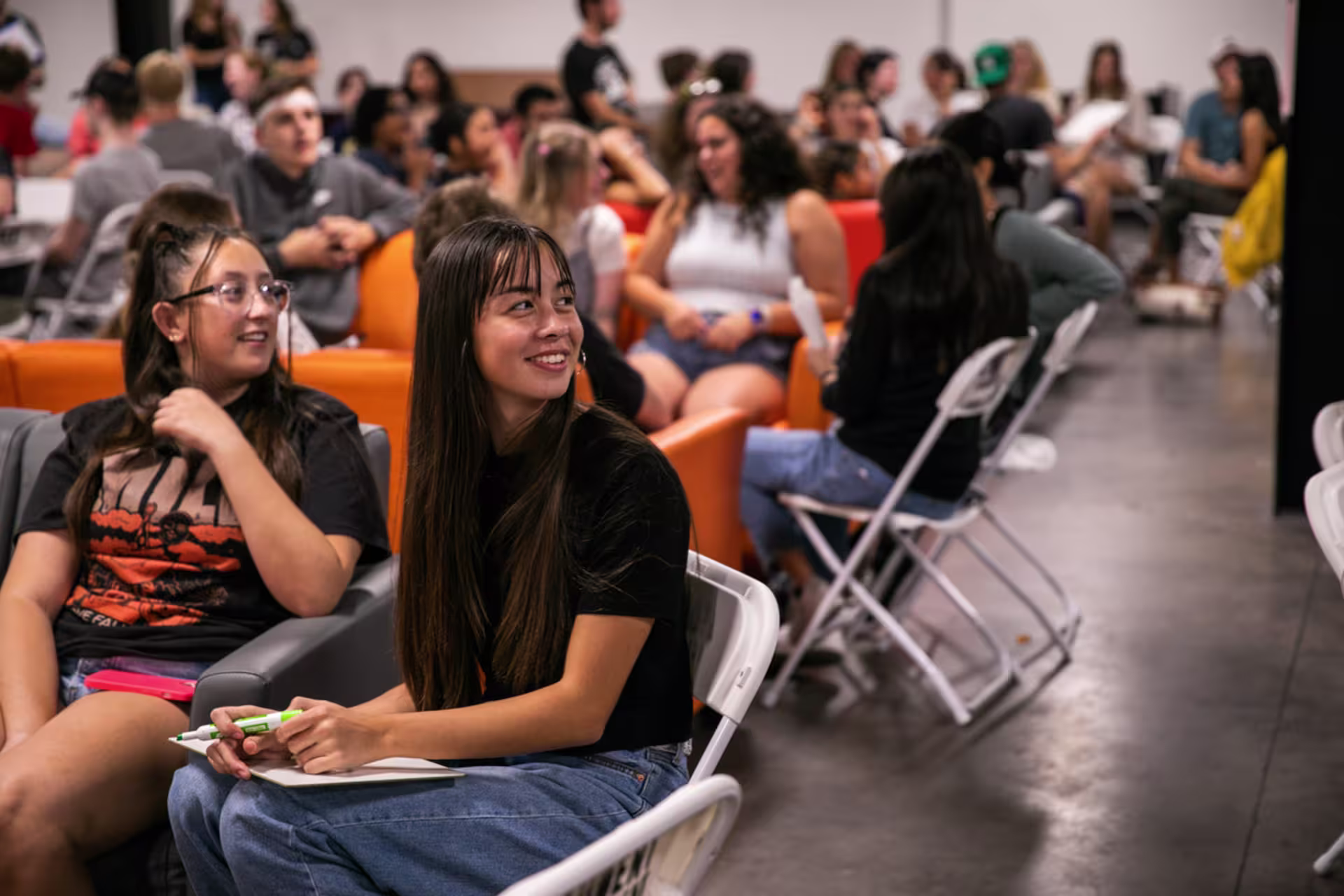 students in multiple groups participate in trivia night in large room