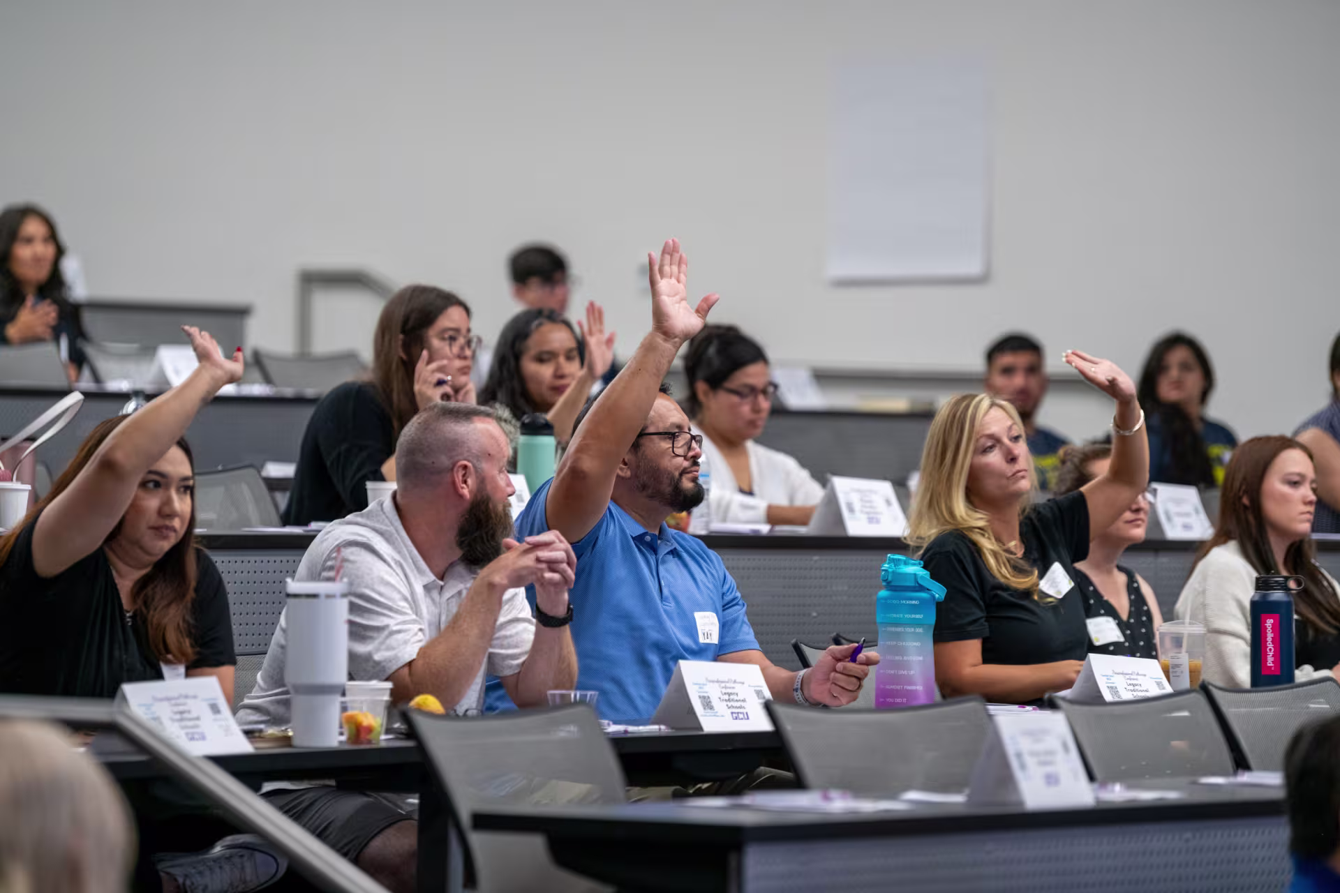 Faculty raising hands at lecture