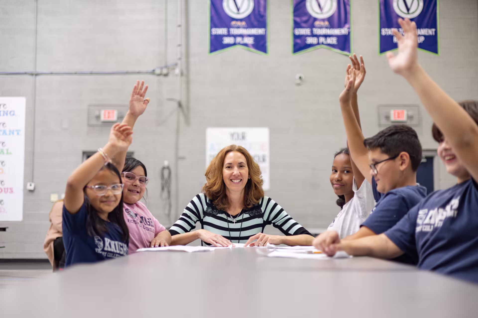 Teacher with students raising their hands