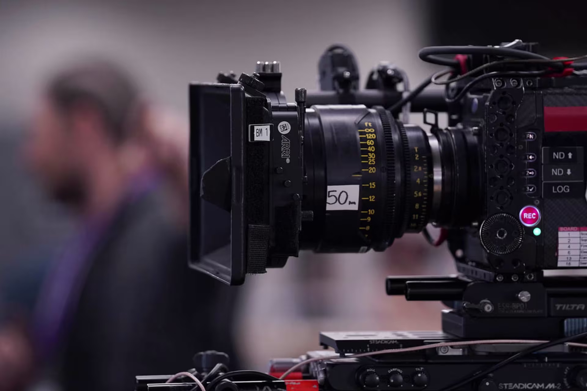 people in background with a close-up view of digital film camera