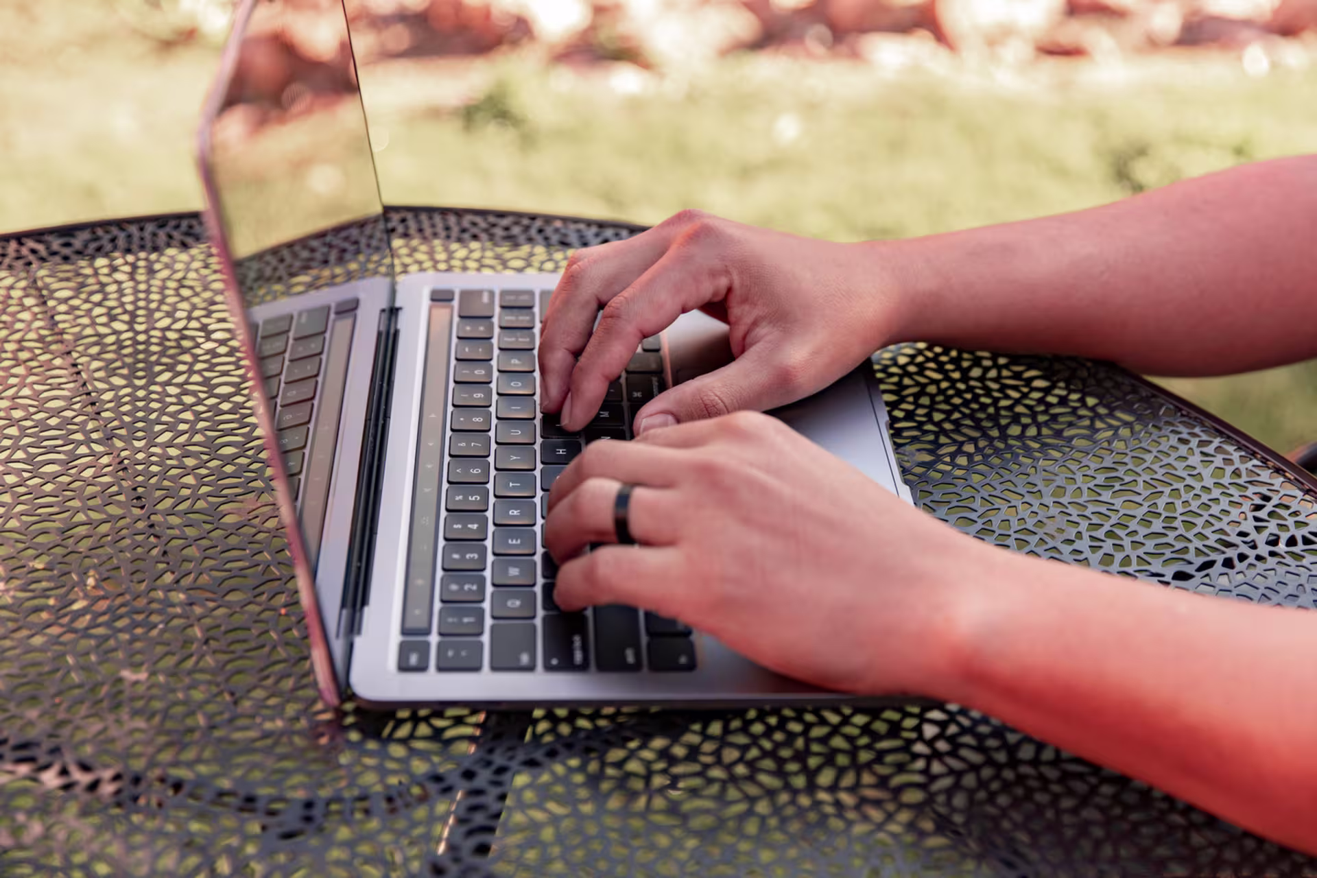 Close up of man at patio table researching types of grants online