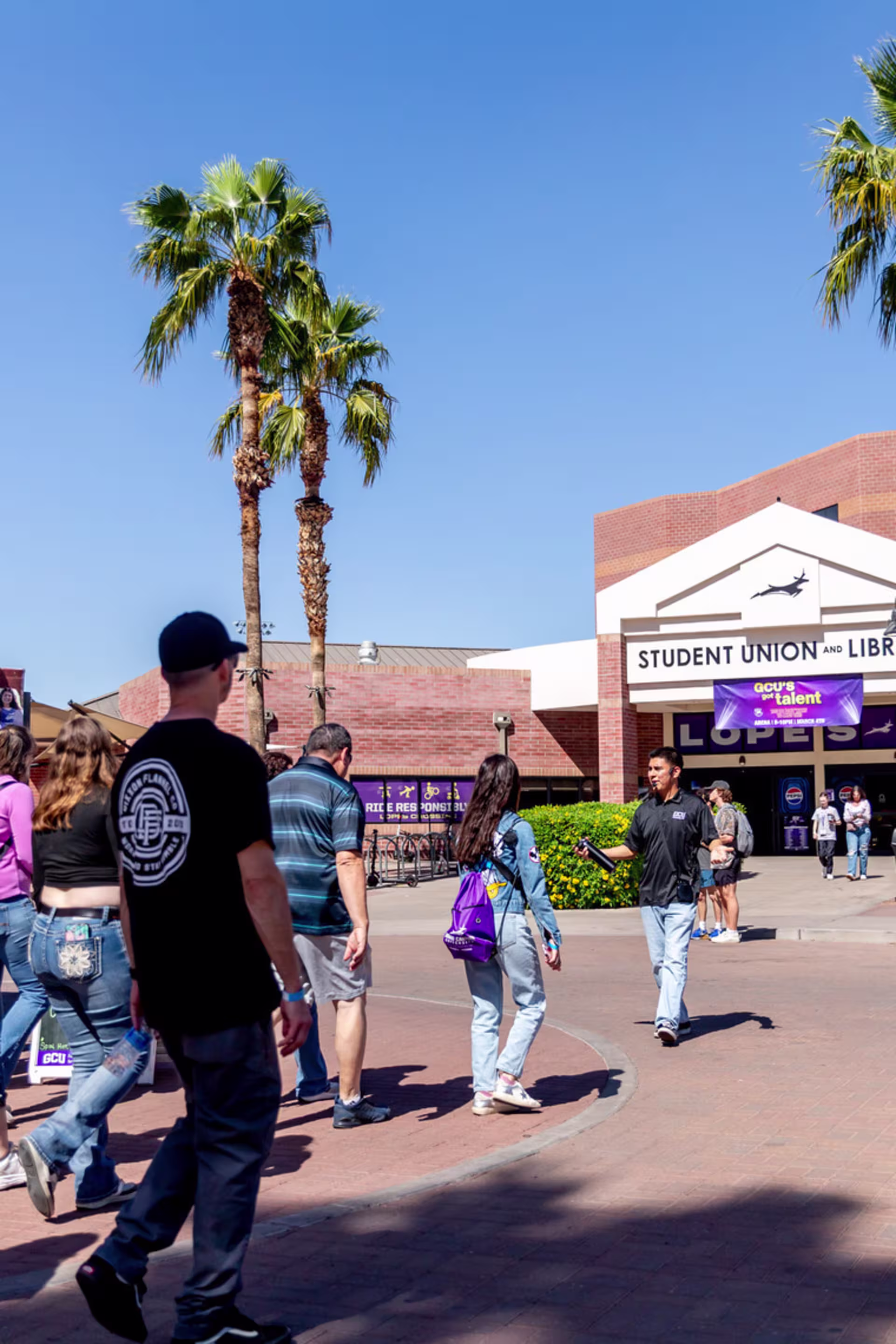 Prospective students and parents on Experience GCU tour with male guide.