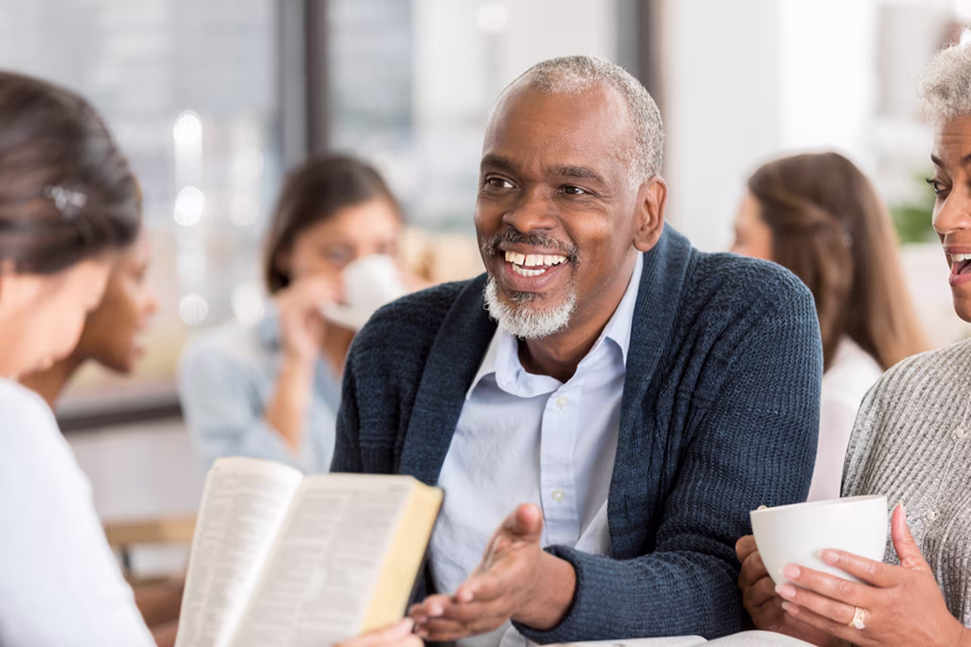 older african-american male shows student an open bible reference