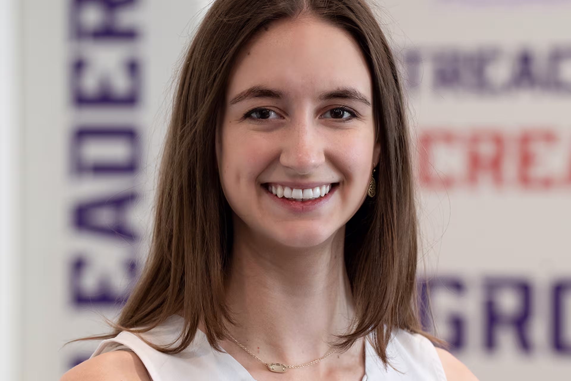 honors program coordinator kendall smith in front of words on wall