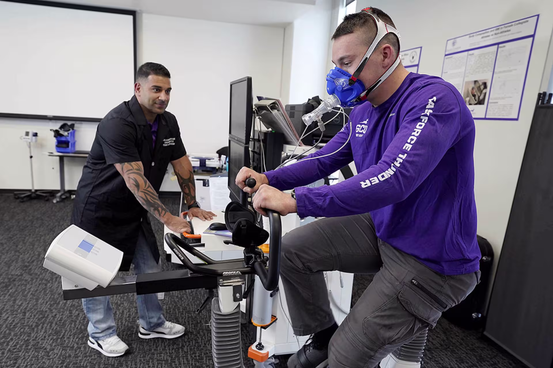 Exercise Physiology student riding a bike while having their vitals monitored