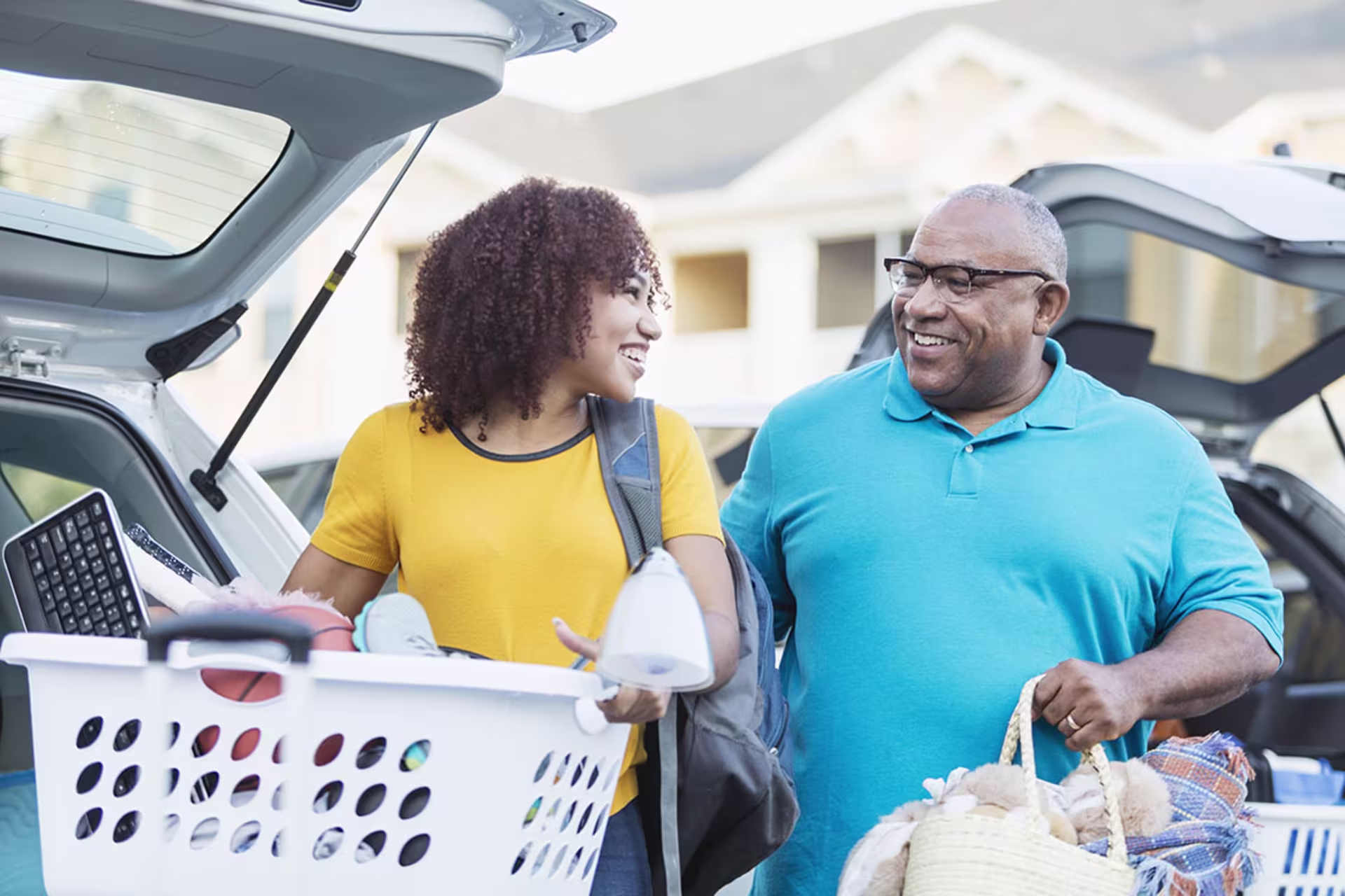 Father helping daughter pack up car to move her belongings for college
