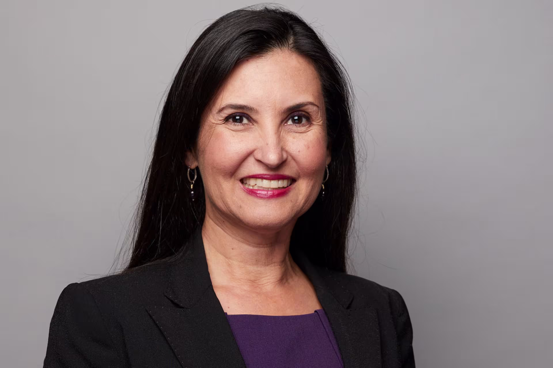 Headshot of Dr. Lupita Hightower wearing black blazer over purple shirt