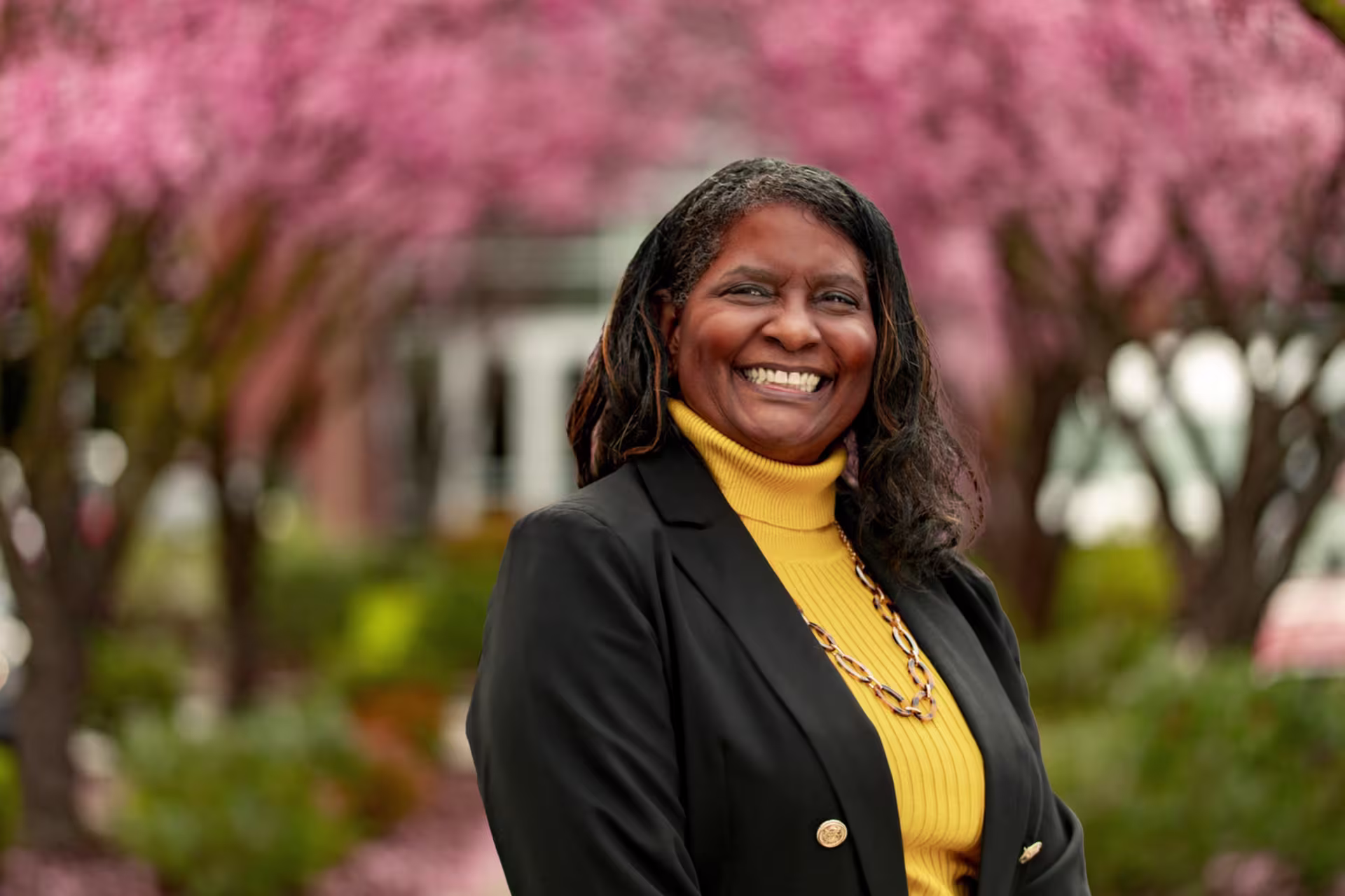 A female smiling in business attire outside