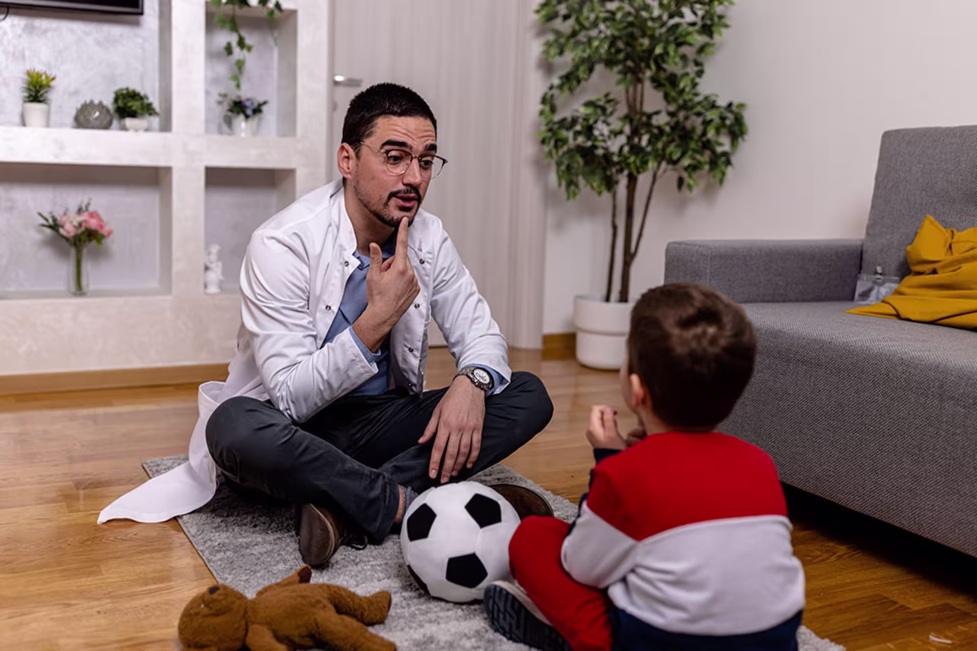 Male speech pathologist working with young male client on diction