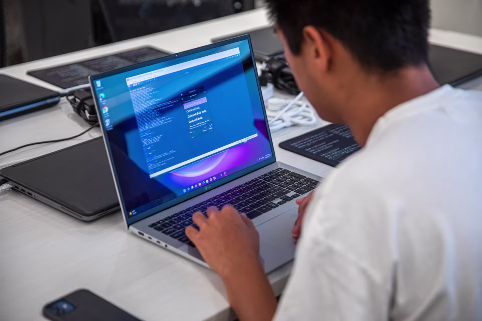 Over the shoulder shot of software development student working on a laptop with code