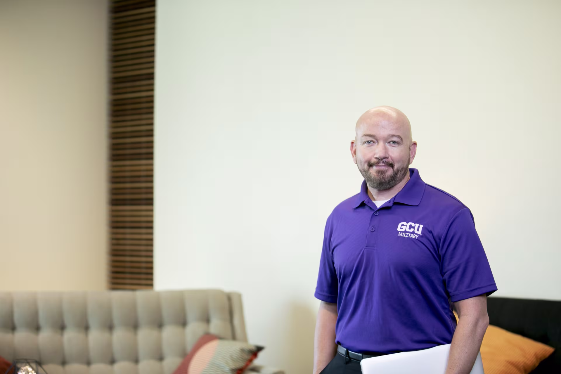 A man standing in a room with clipboard