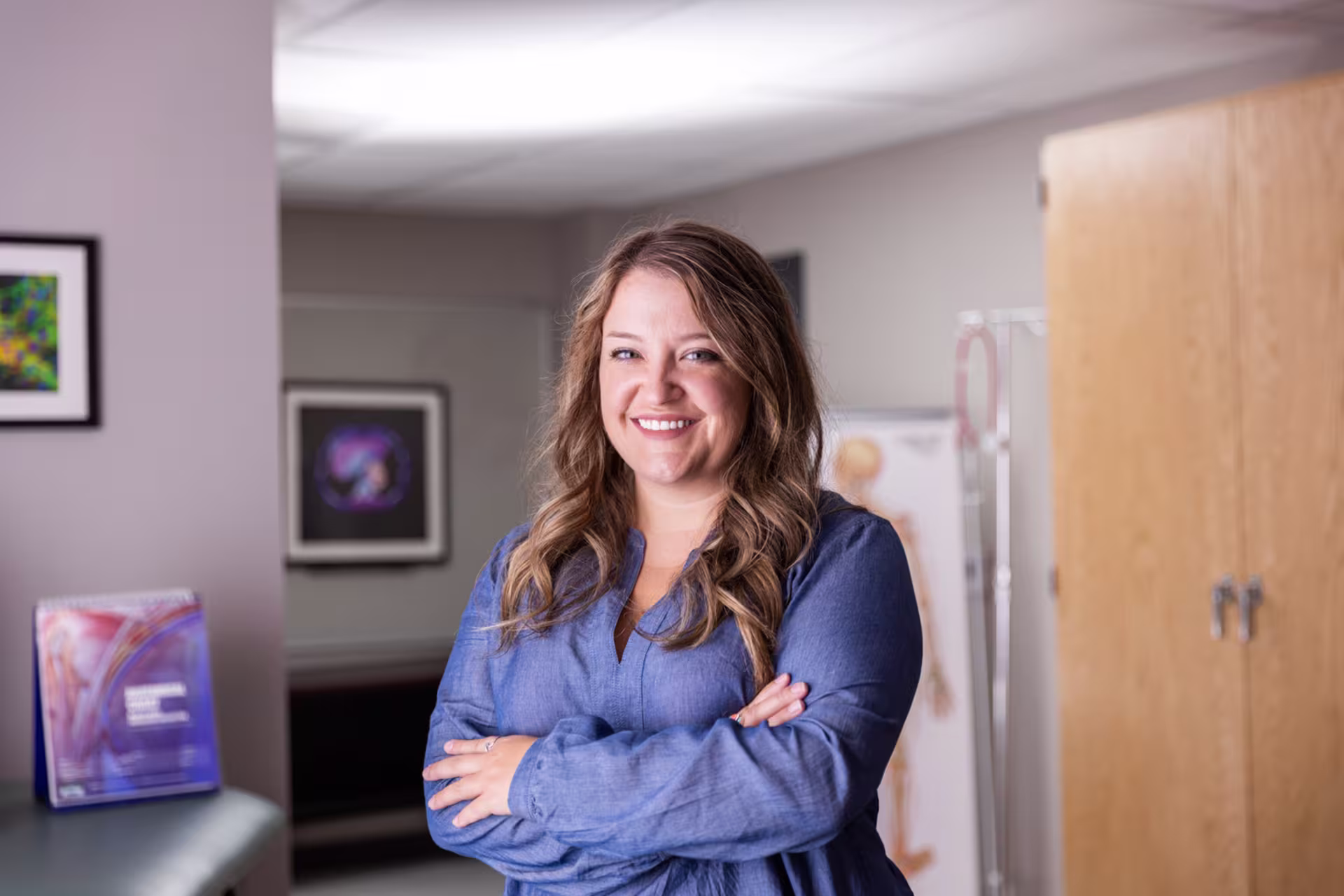 Behavioral health sciences professional standing in a clinic setting with her arms crossed.