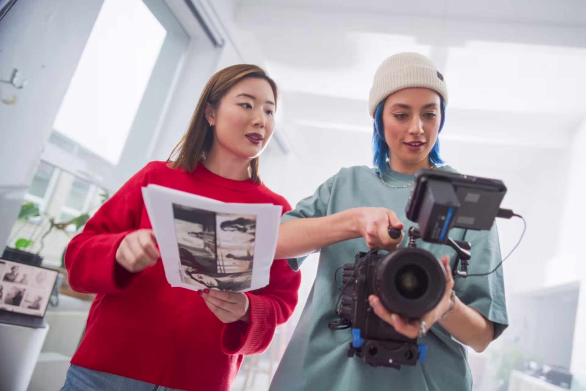 Digital film production students work on a film shoot with a camera and script.