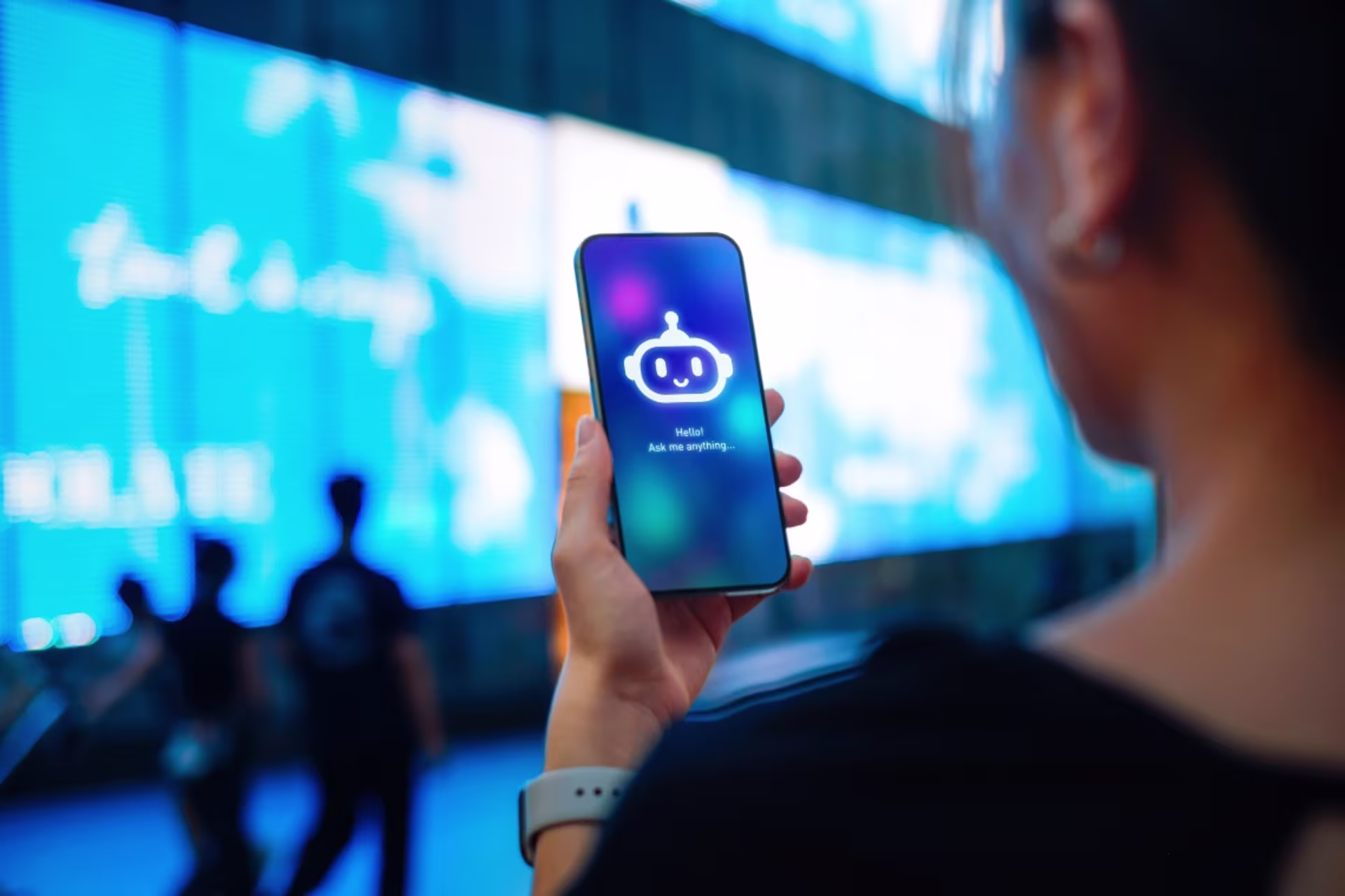 Woman holding a phone with an AI programming robot on the screen.