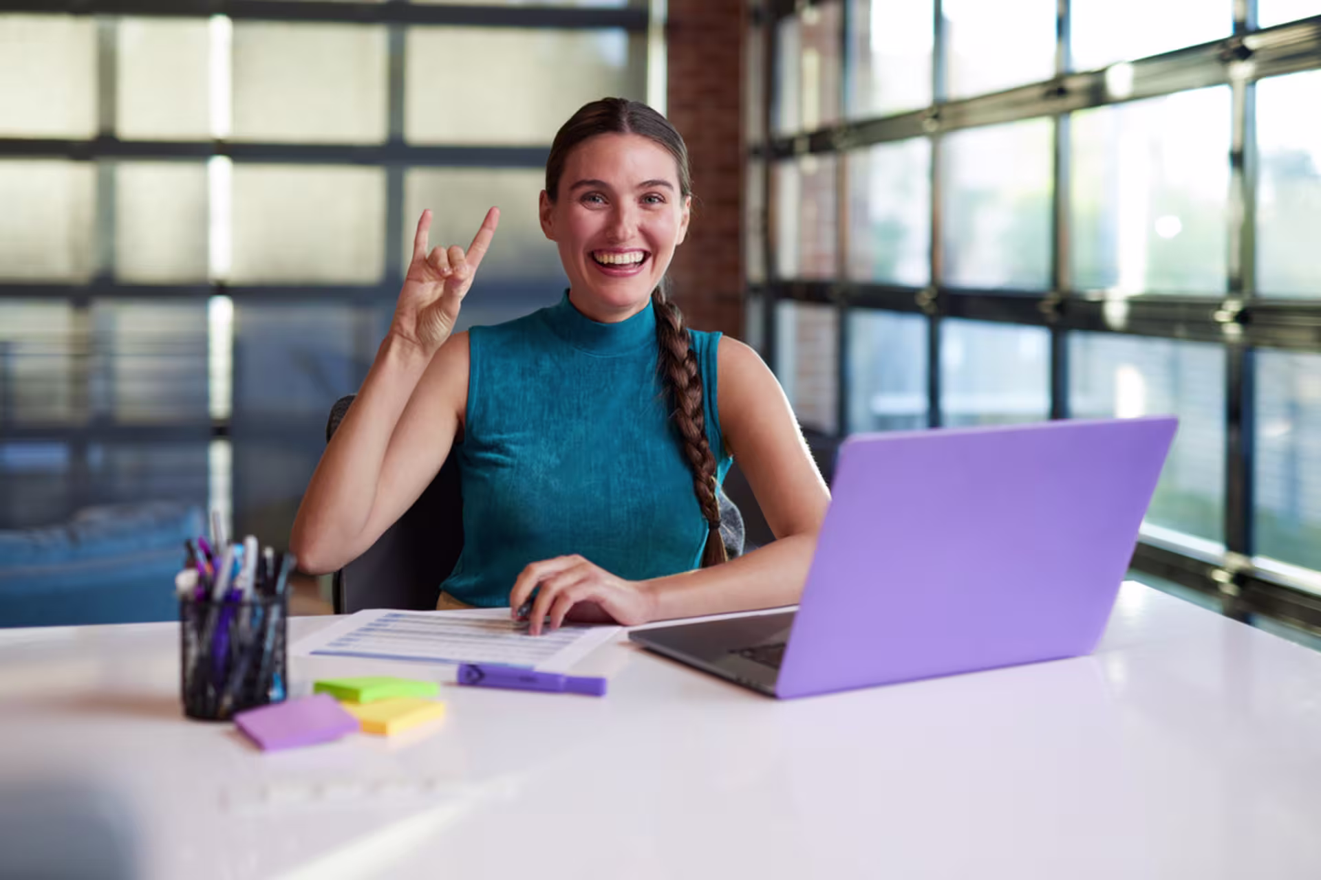Accounting MBA student sitting at a desk while working on a purple laptop.