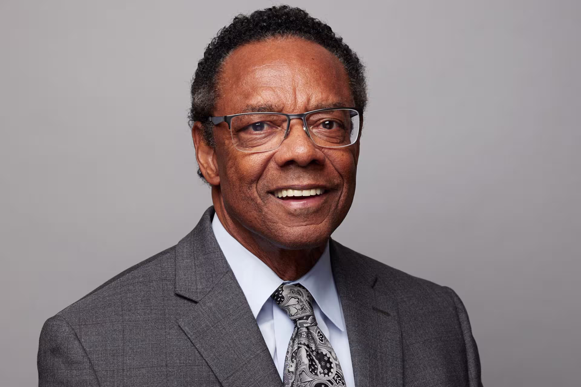 Headshot of Fred Miller wearing glasses and grey suit with tie.