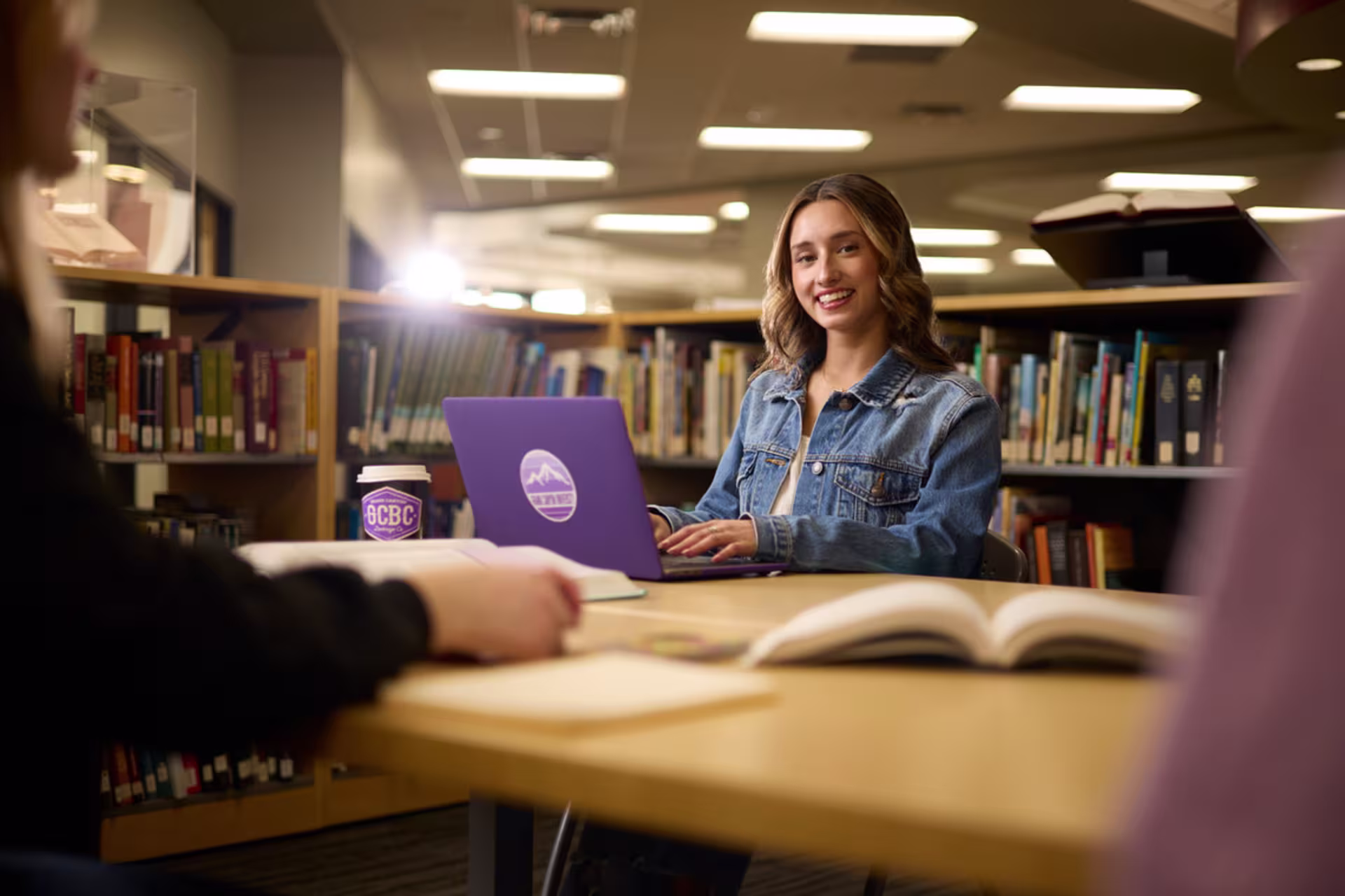 Master’s of reading student on laptop in the library.