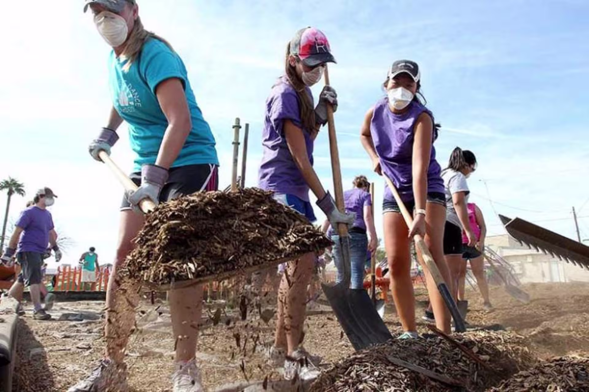 Group of people shoveling at community service