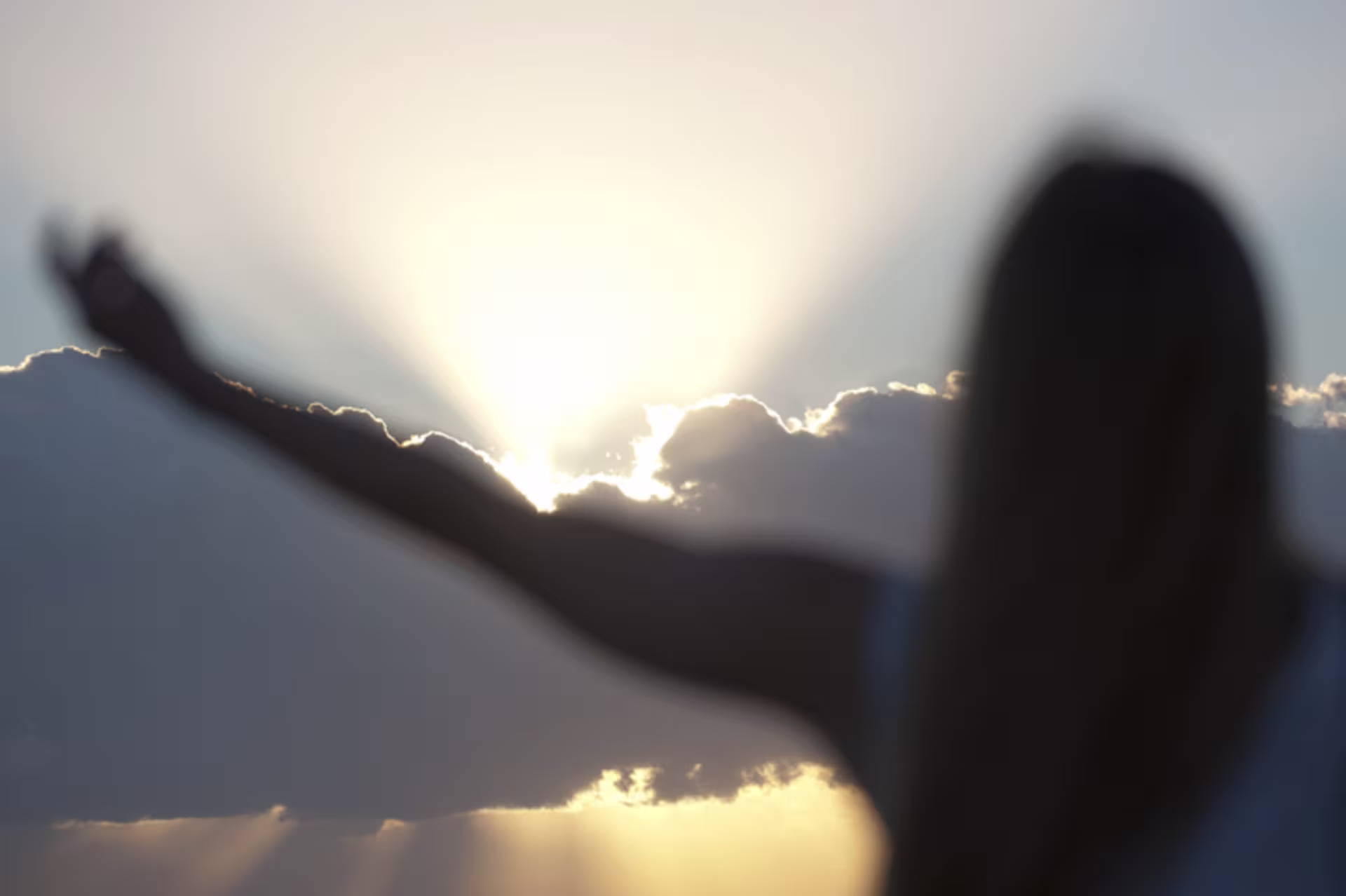 woman stretching out arms to the sky