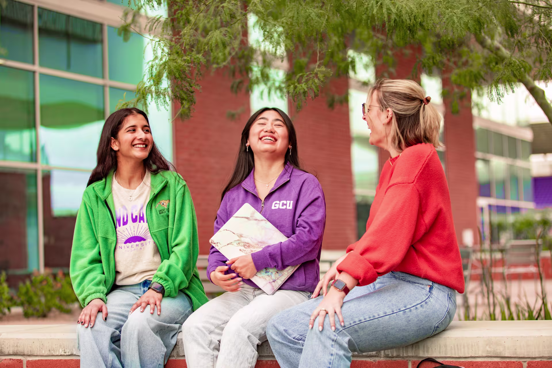Three female psychology majors laughing outside