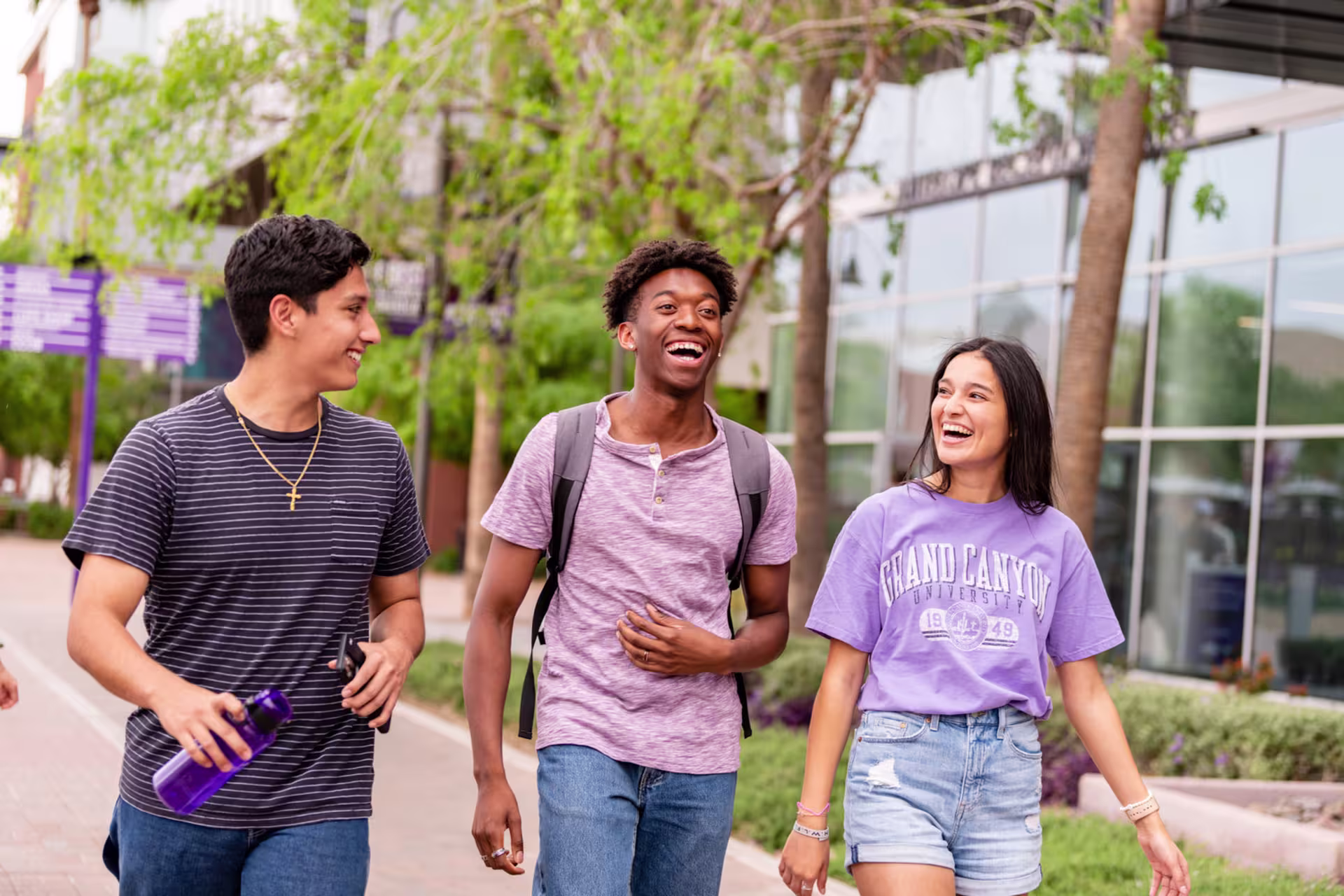 A few GCU students in the College of Humanities and Social Sciences walking outside on campus.