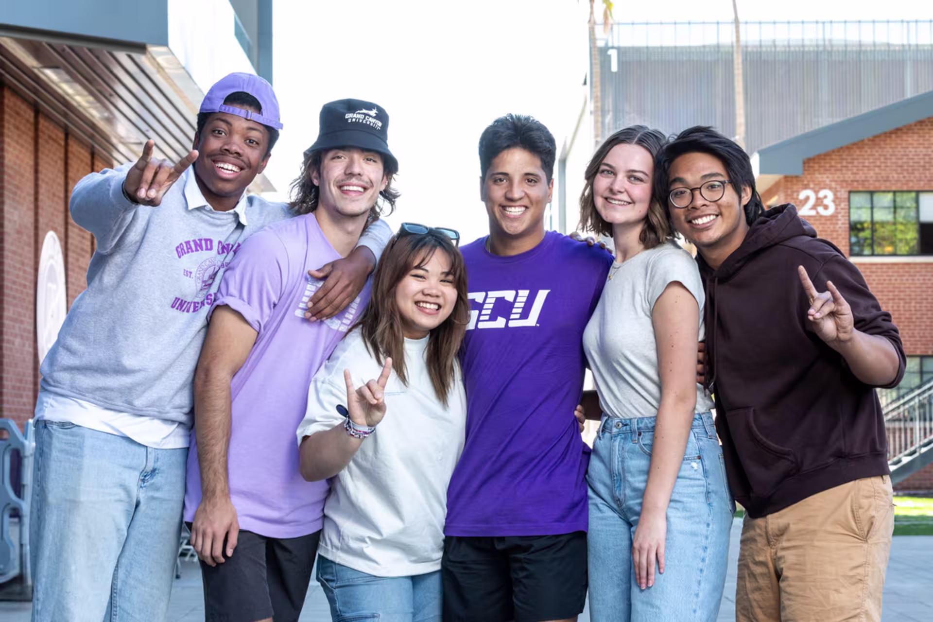 ethnic group of GCU students in a group photo giving Lopes Up hand signs