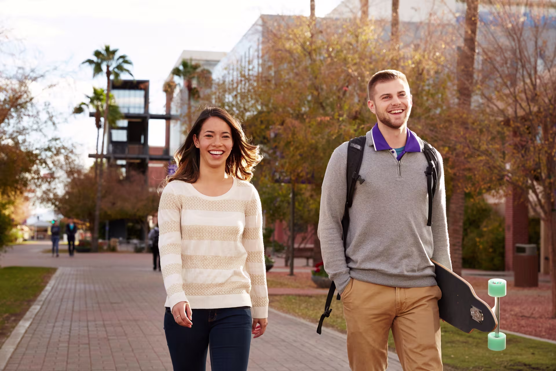 Female and male students walking together outside of campus.