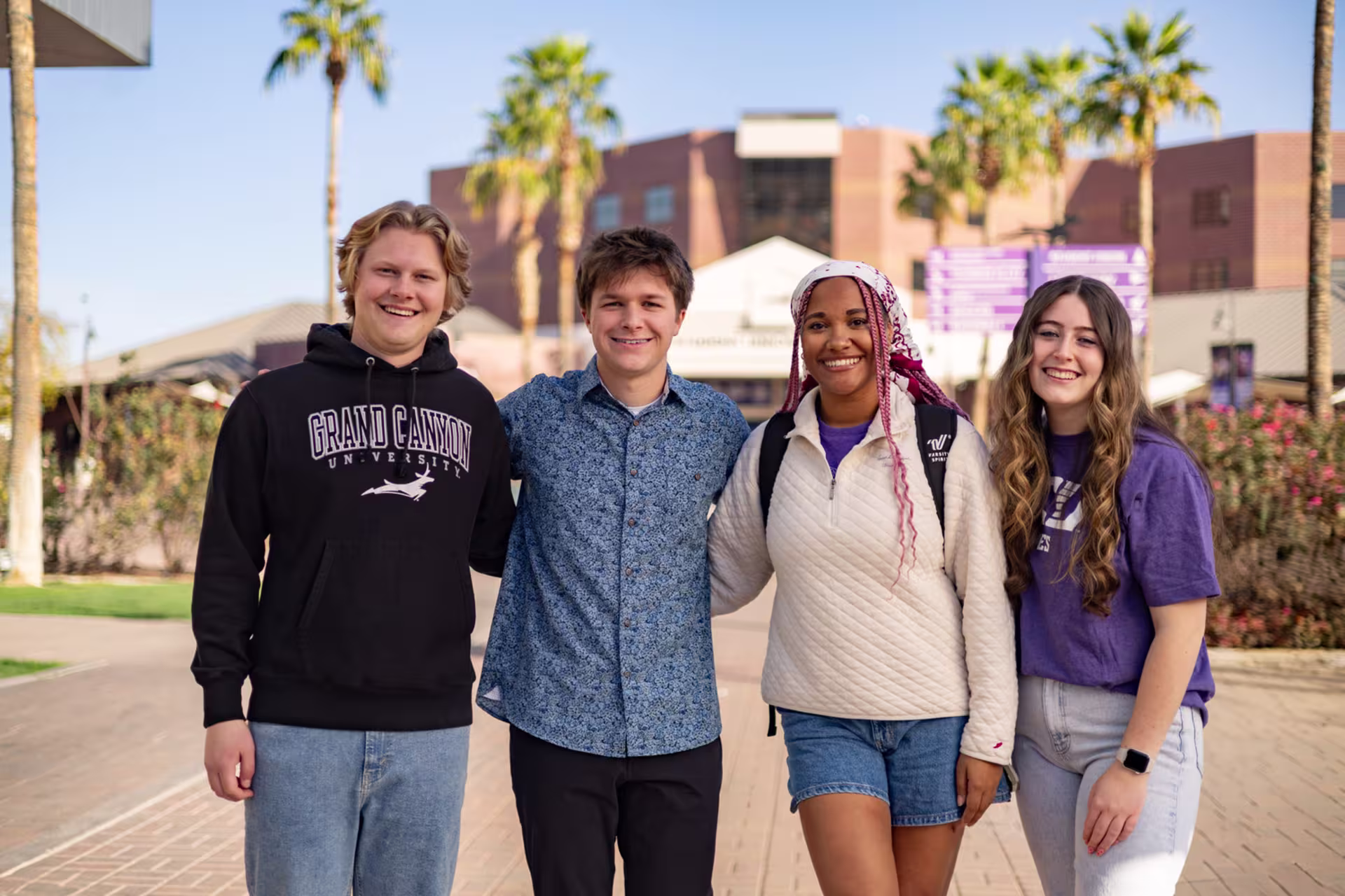 Group of male and female college students smiling together on campus.