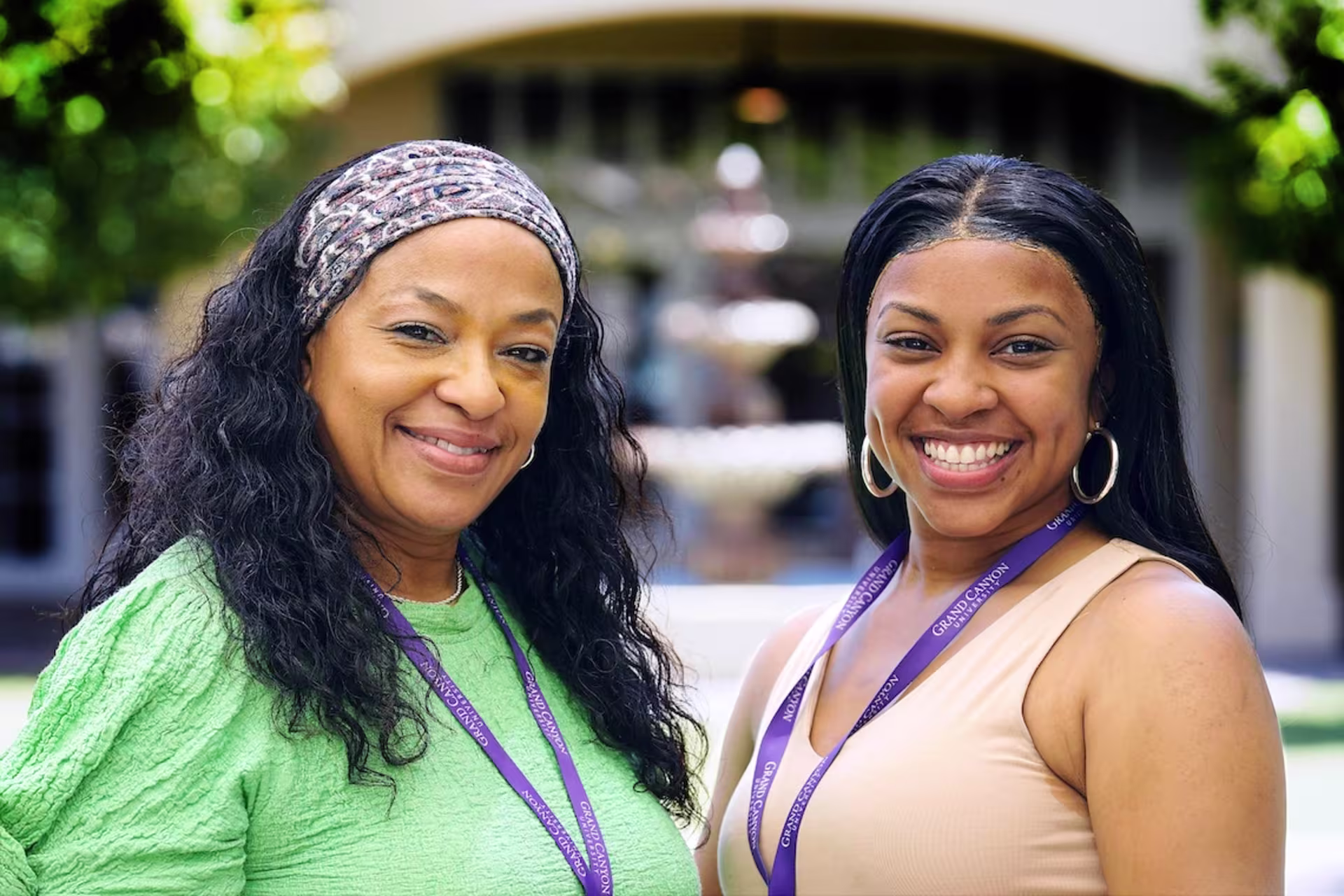 two female life coaching certificate students smiling in hallway.