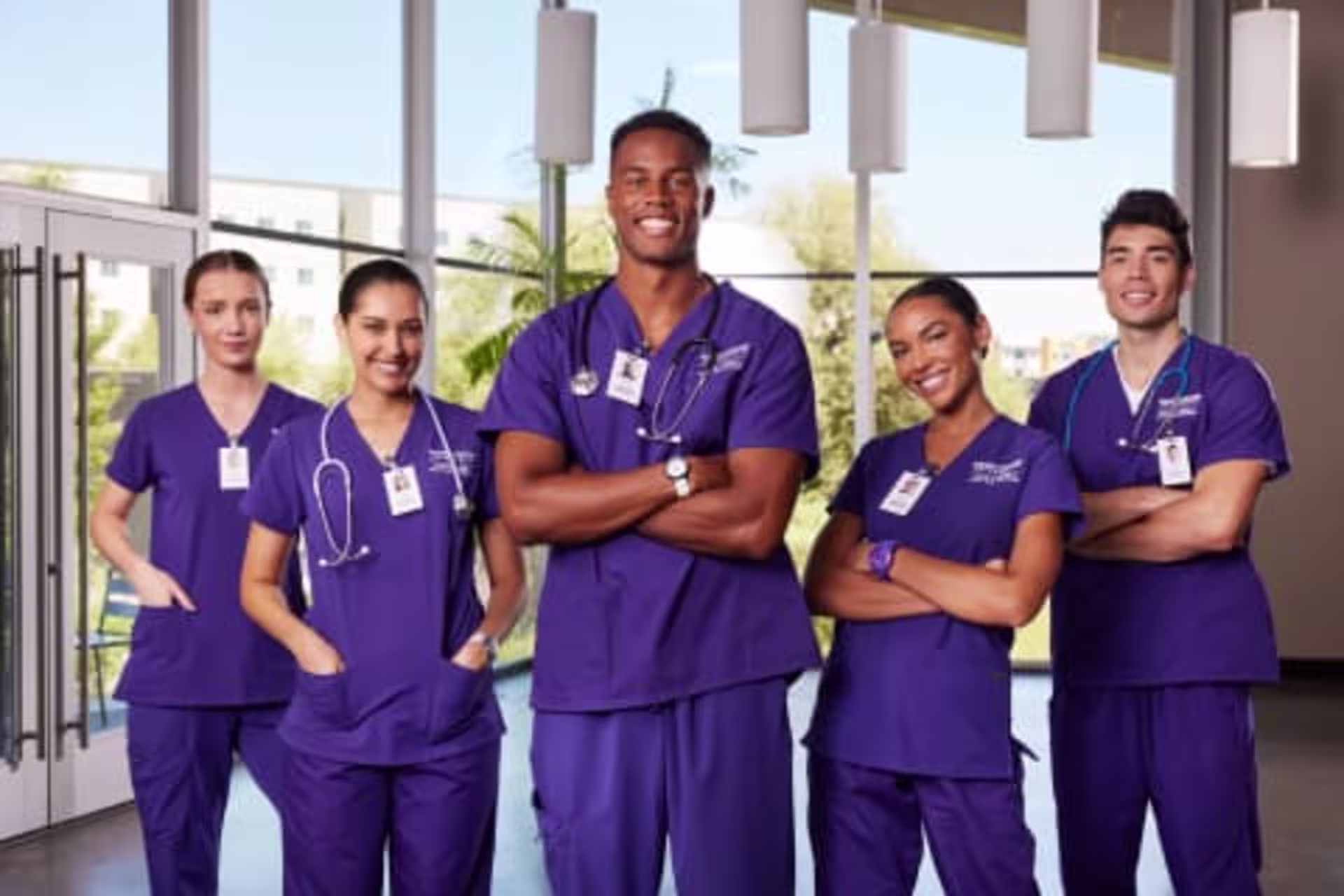 Group of male and female BSN students smiling in GCU scrubs.