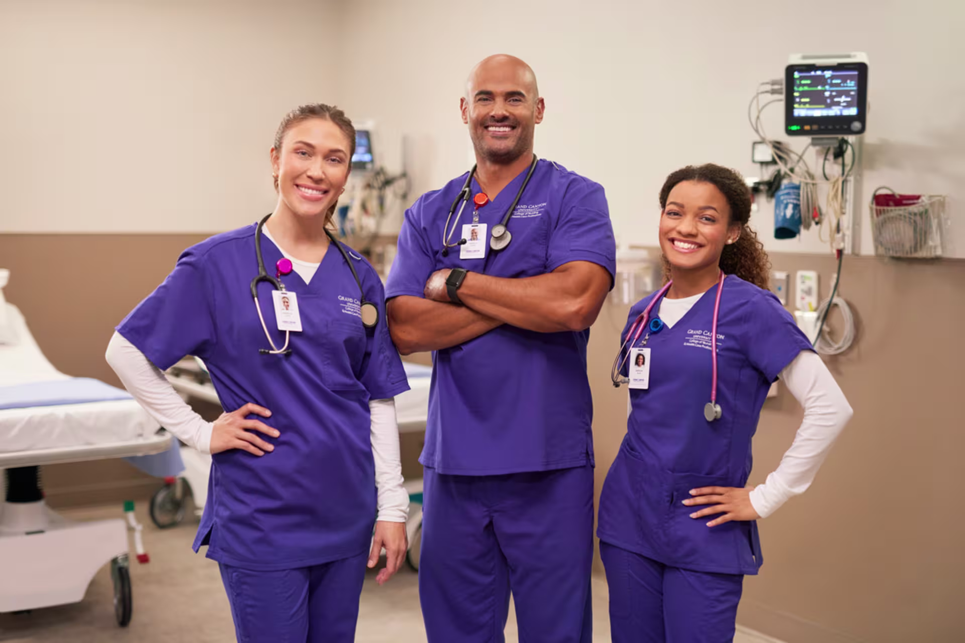 one male and two female absn students pose in clinical room